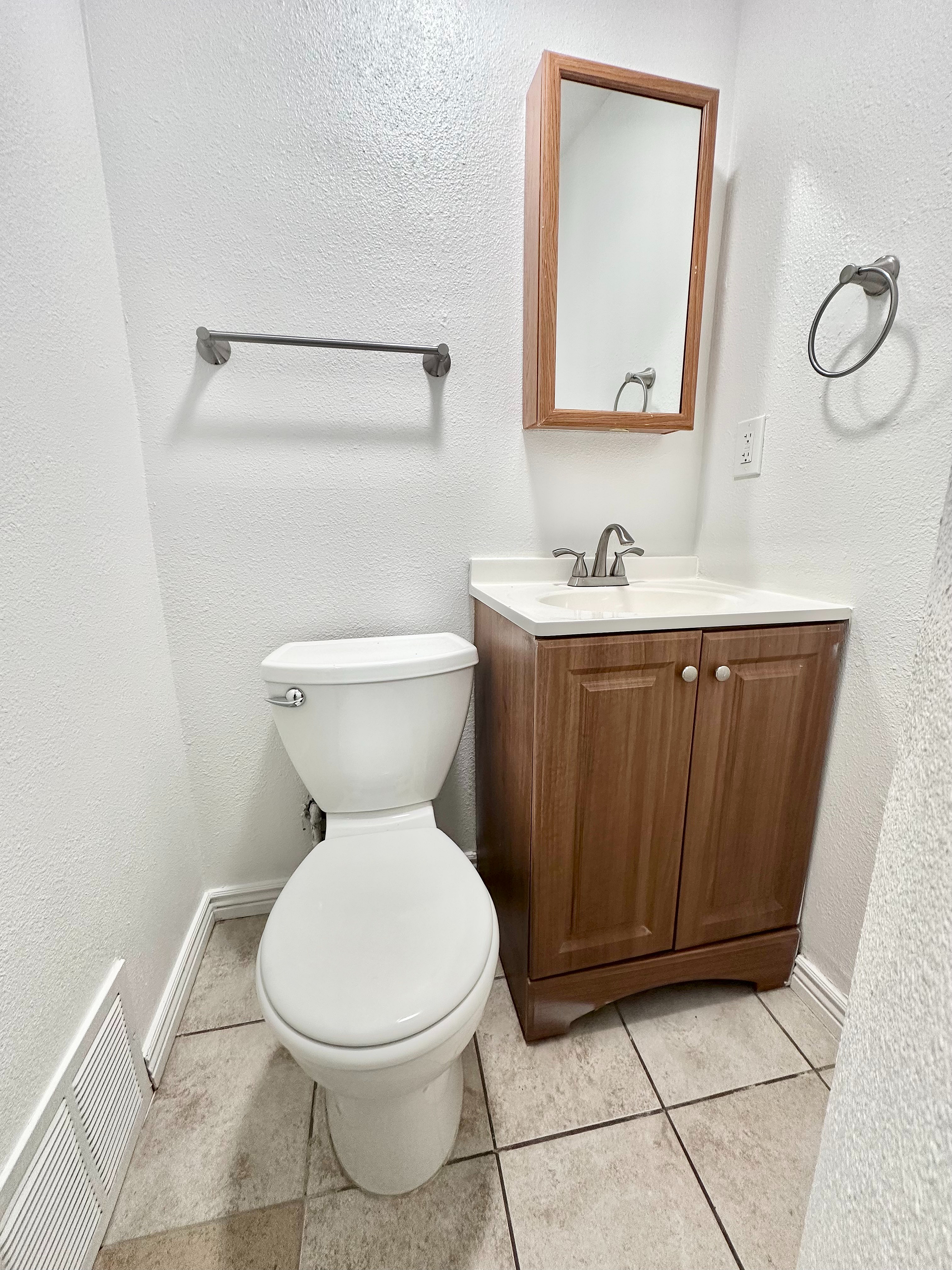 Inviting bathroom with sleek modern fixtures, elegant tile flooring, and a stylish wooden vanity.