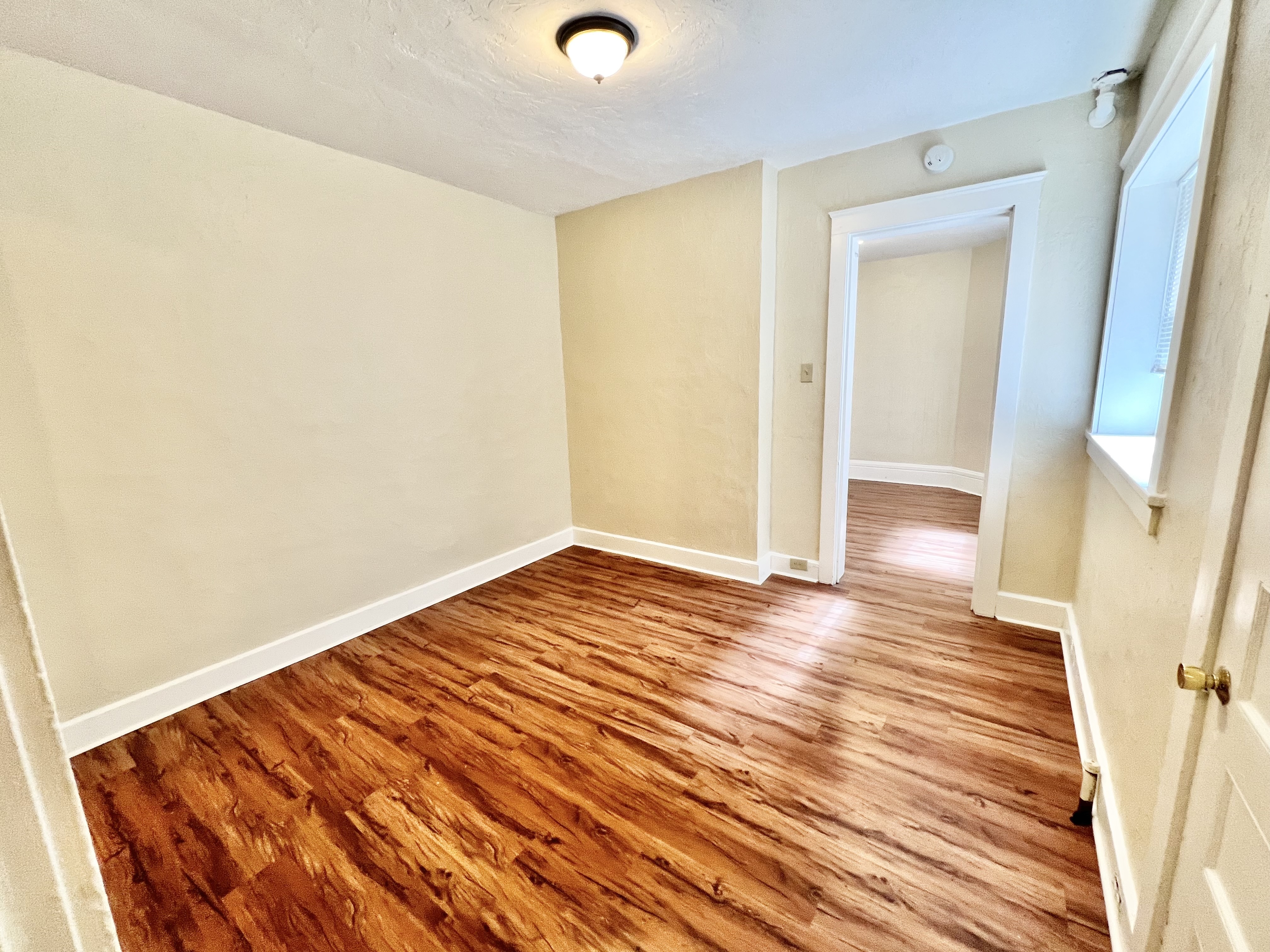 Bright and airy room with elegant wooden flooring and clean, neutral walls, perfect for creative interior designing.
