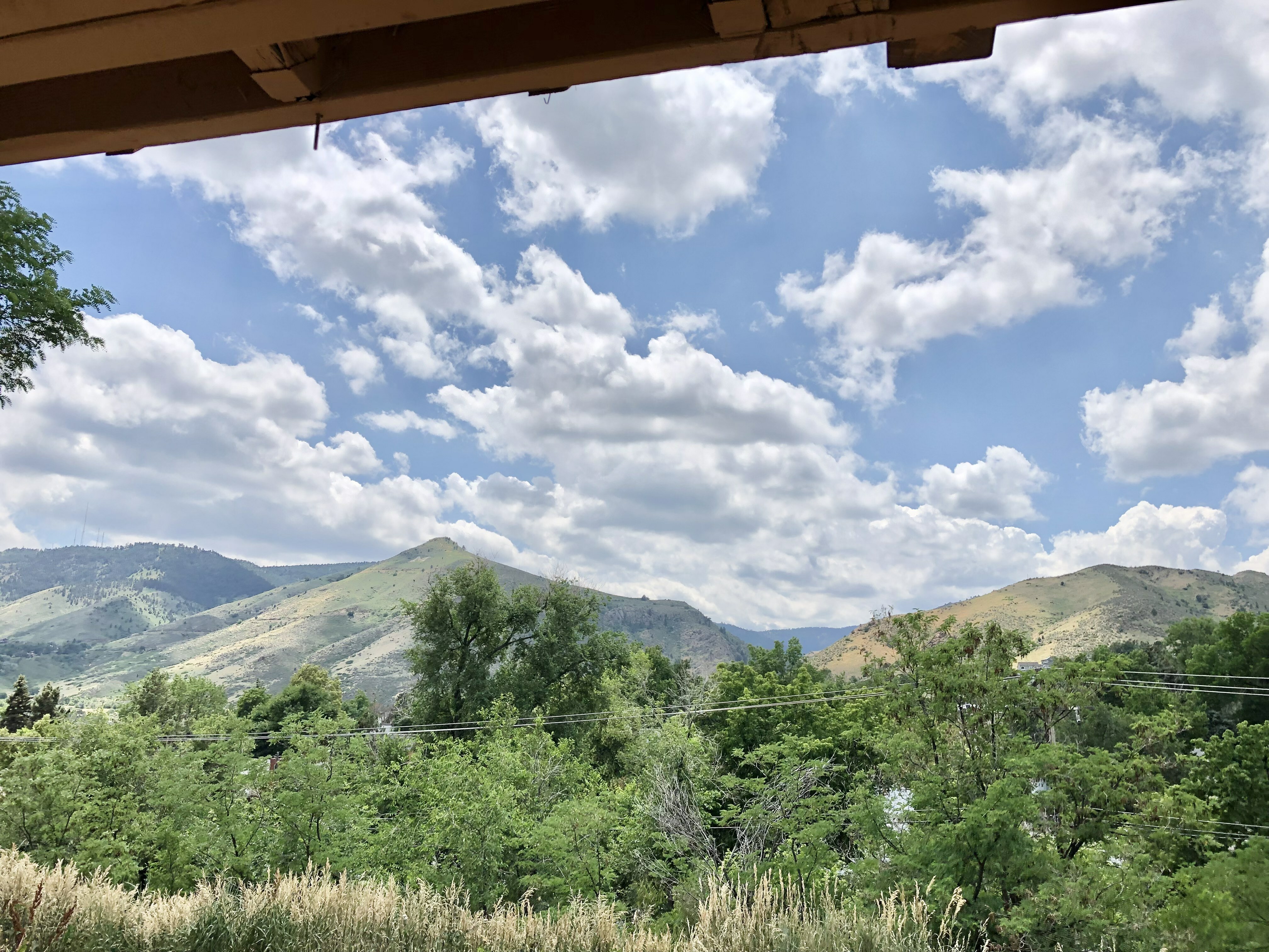 Breathtaking view of a lush, green landscape with rolling hills under a vibrant blue sky filled with fluffy clouds.