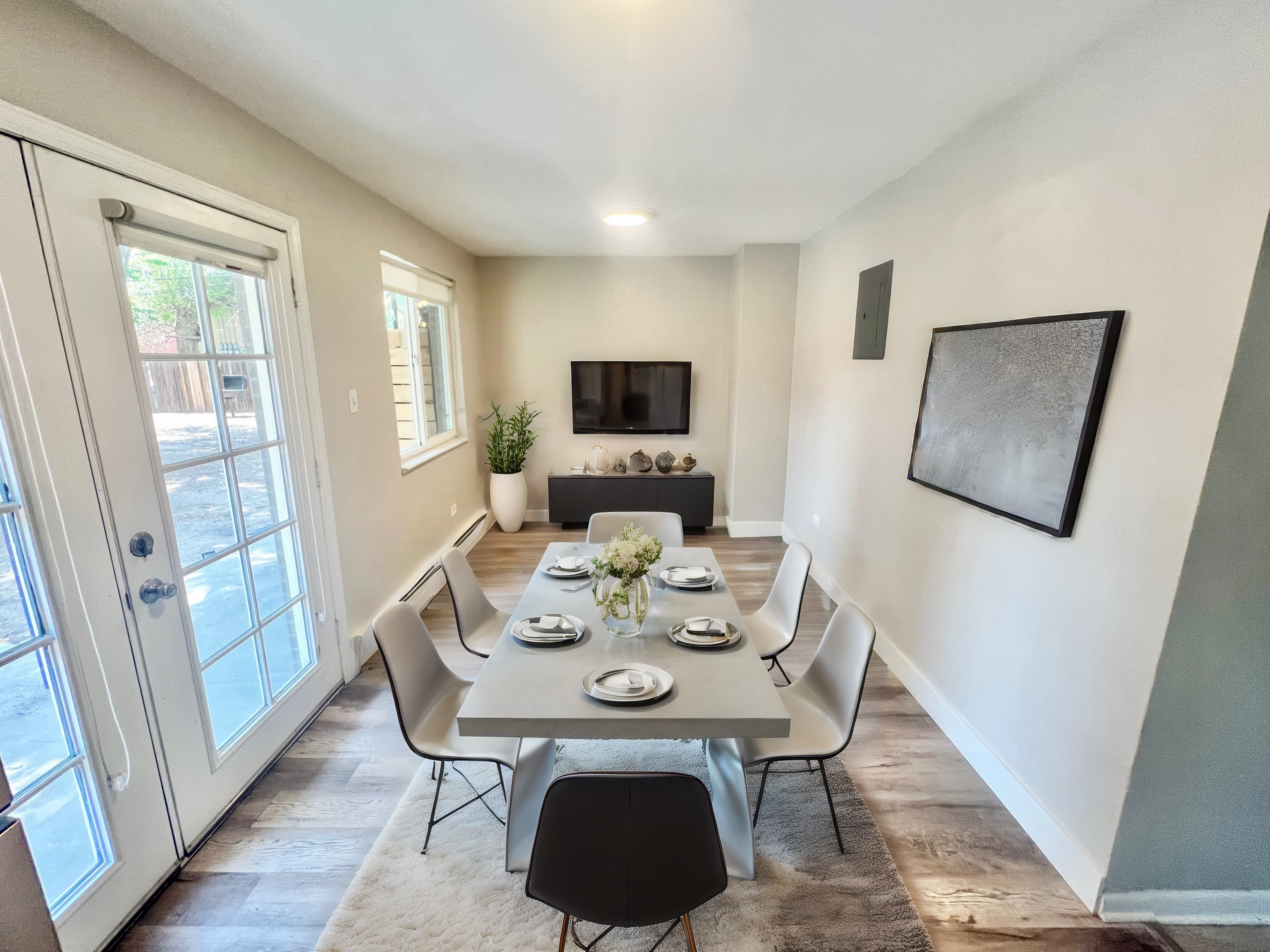 Bright dining area with modern table setting, large windows, and elegant decor, perfect for entertaining.