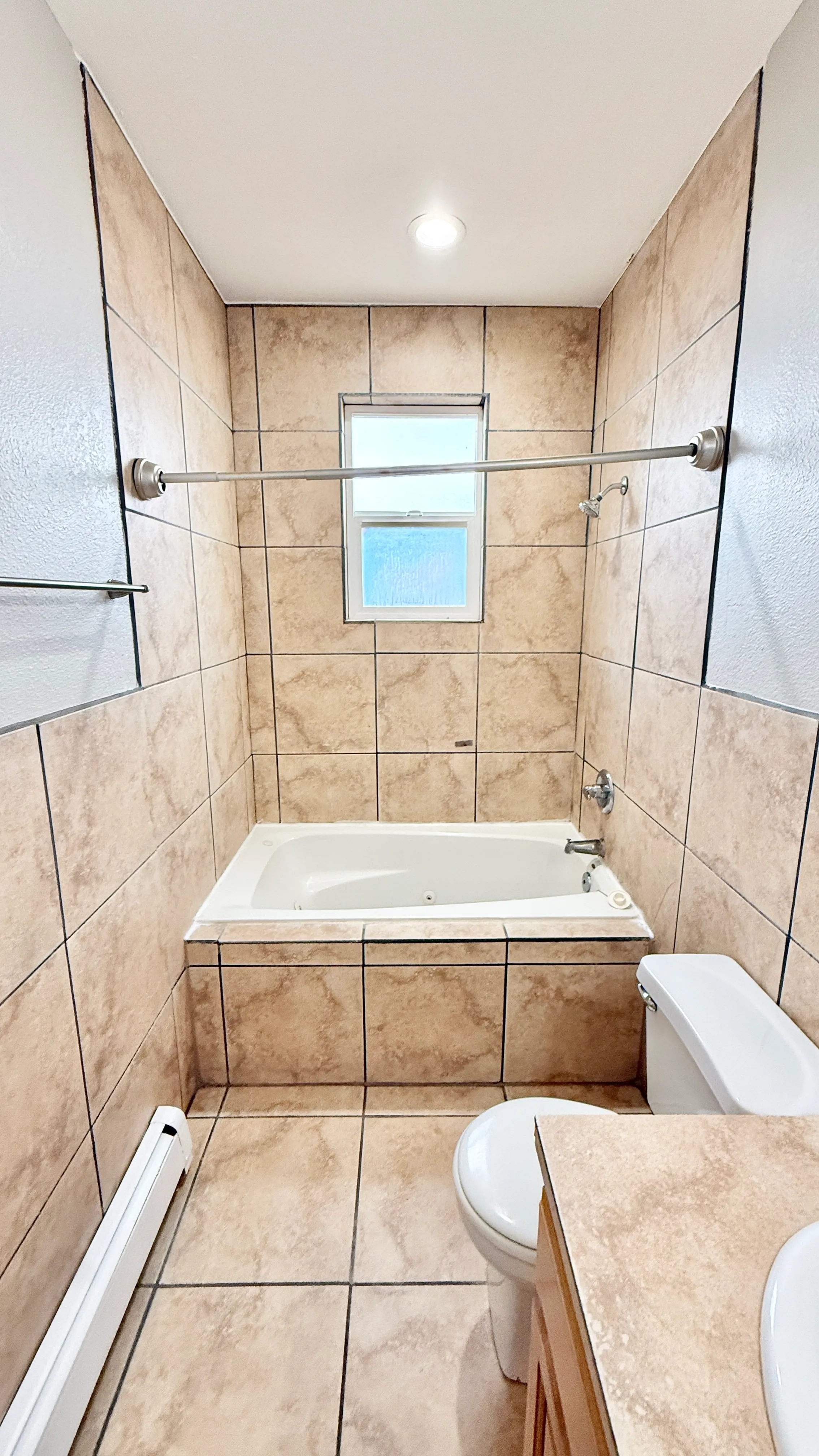 Modern bathroom featuring elegant tile design, a relaxing bathtub, and ambient lighting.