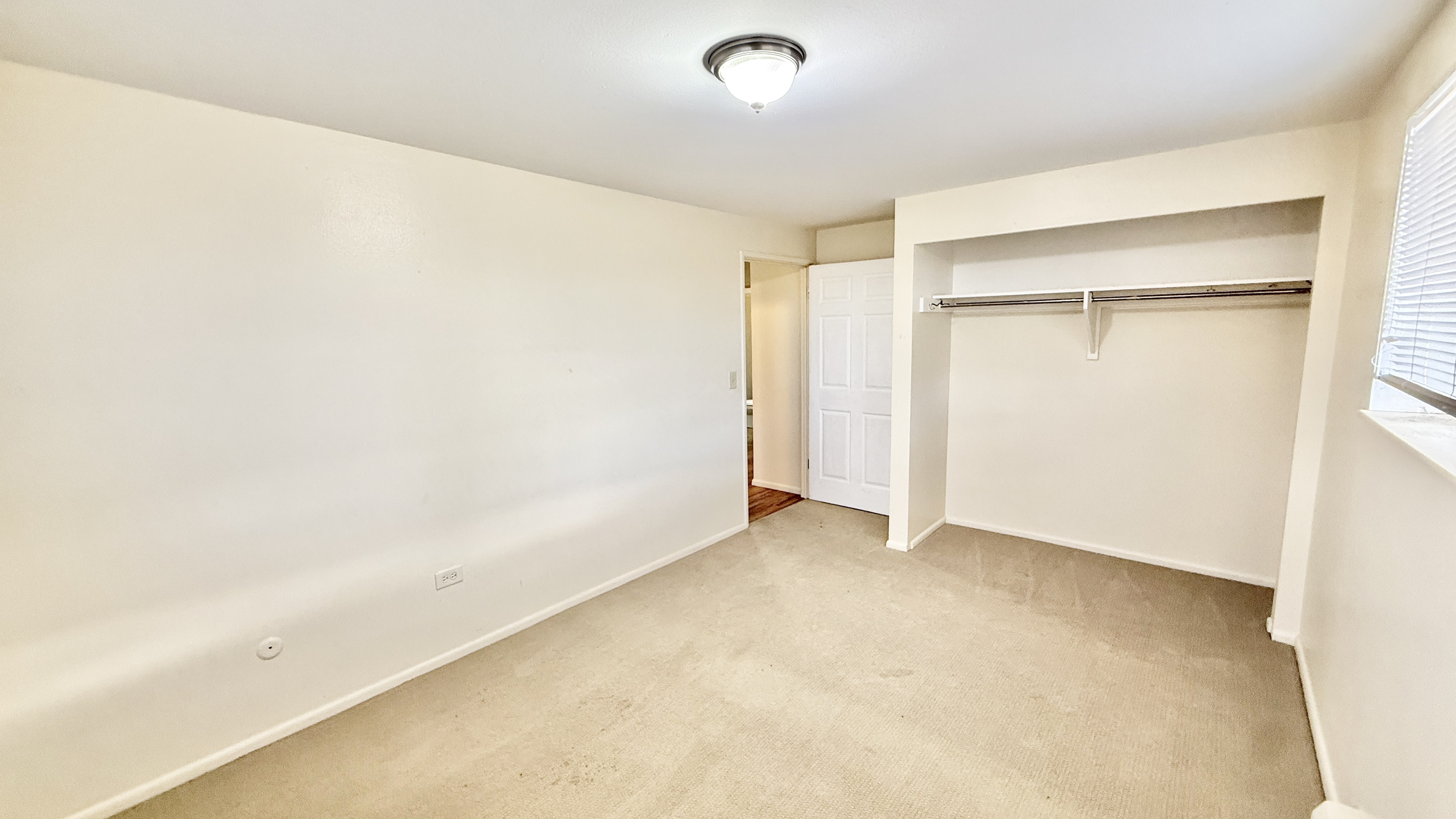 Bright, spacious bedroom with a built-in closet, ready for customization and plenty of natural light.