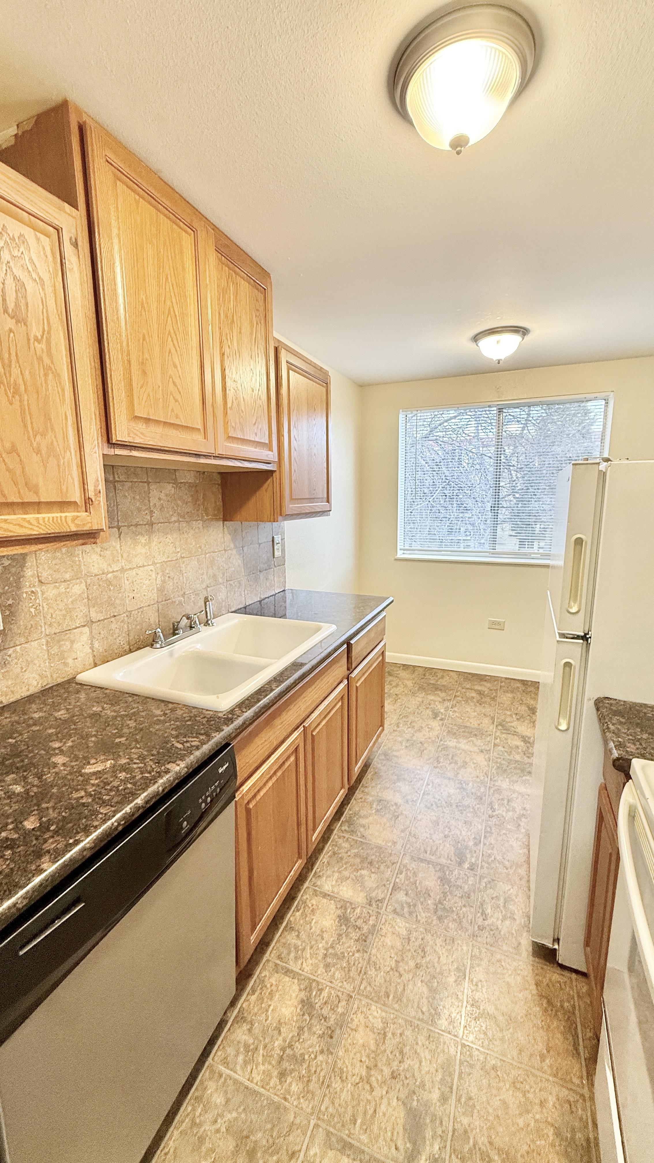 Bright kitchen with elegant wood cabinets, granite countertops, and modern appliances offering a cozy and functional cooking space.