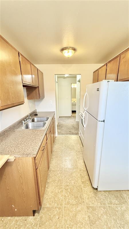 Bright and inviting kitchen with wooden cabinets, sleek countertops, and modern appliances, offering a warm and functional space.