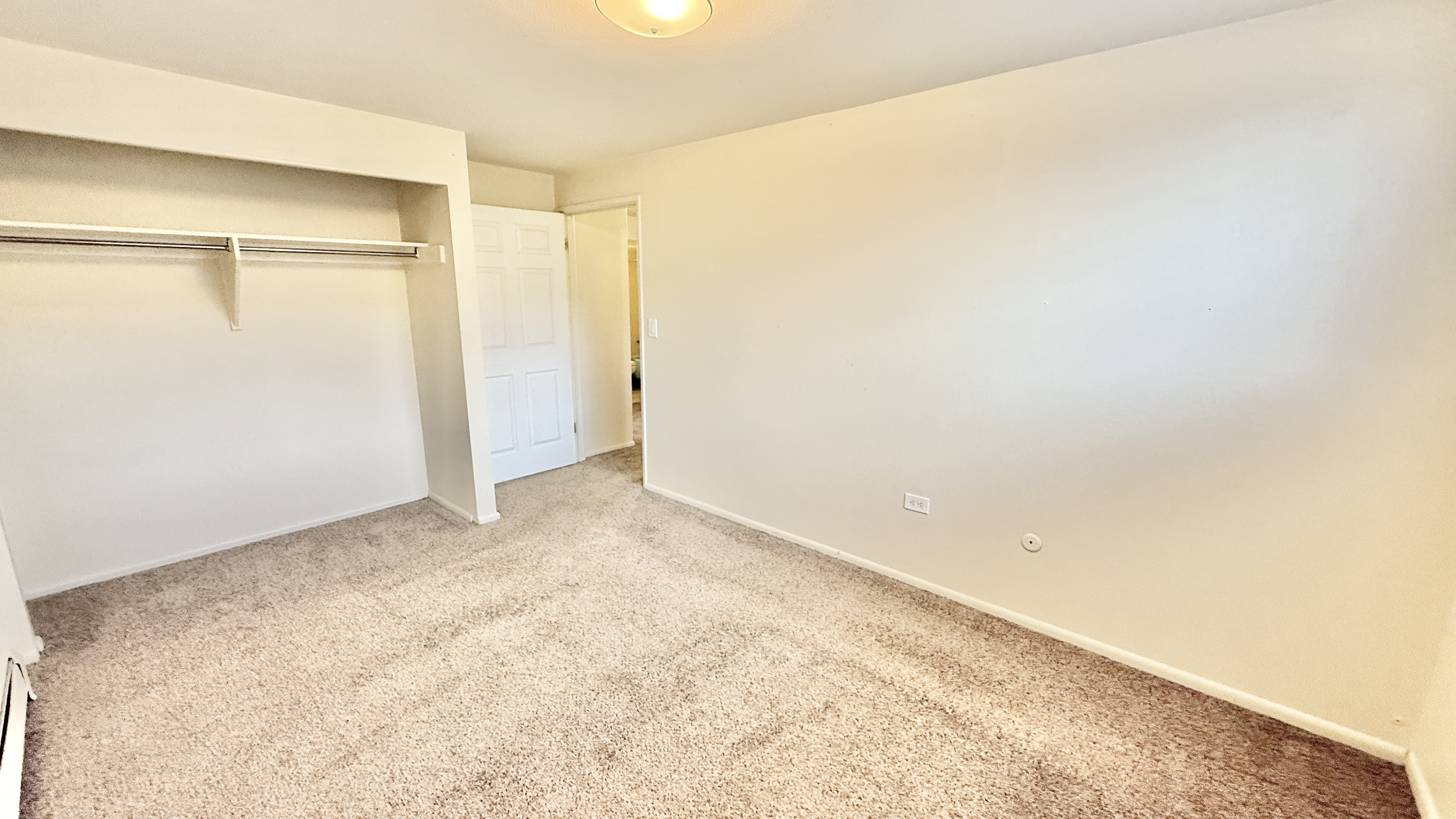 Bright and airy bedroom with plush carpeting, ample closet space, and soft, neutral walls.