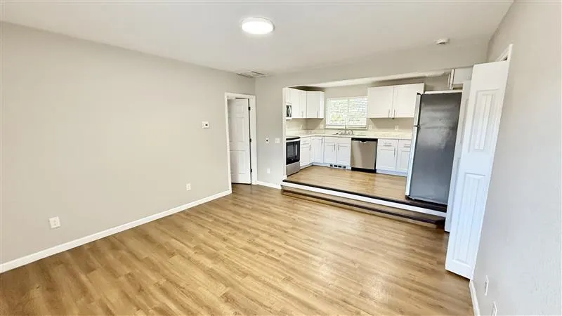 Bright open-concept living space with modern kitchen, sleek hardwood floors, and abundant natural light.
