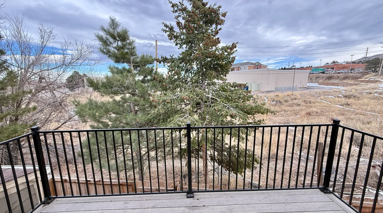 Charming balcony view with scenic trees and open sky, perfect for outdoor relaxation.