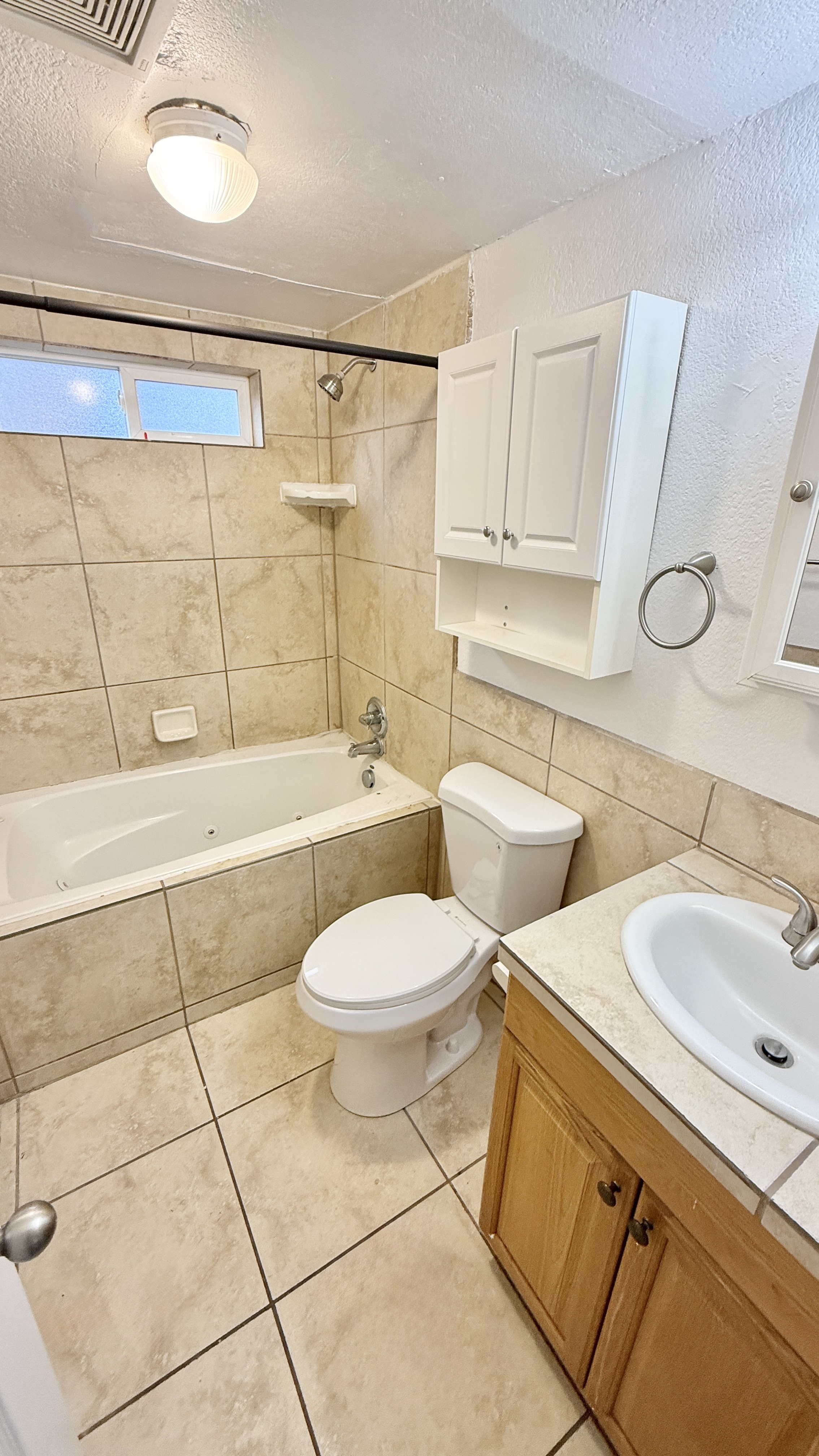 Bright and inviting bathroom with elegant tiling, fitted bathtub, and modern fixtures.