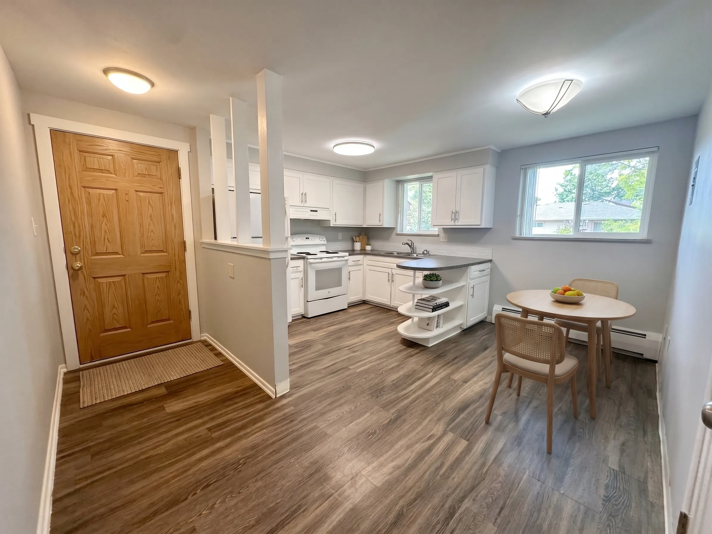 Bright and airy kitchen with modern appliances, sleek countertops, and a cozy dining area, featuring large windows for natural light.