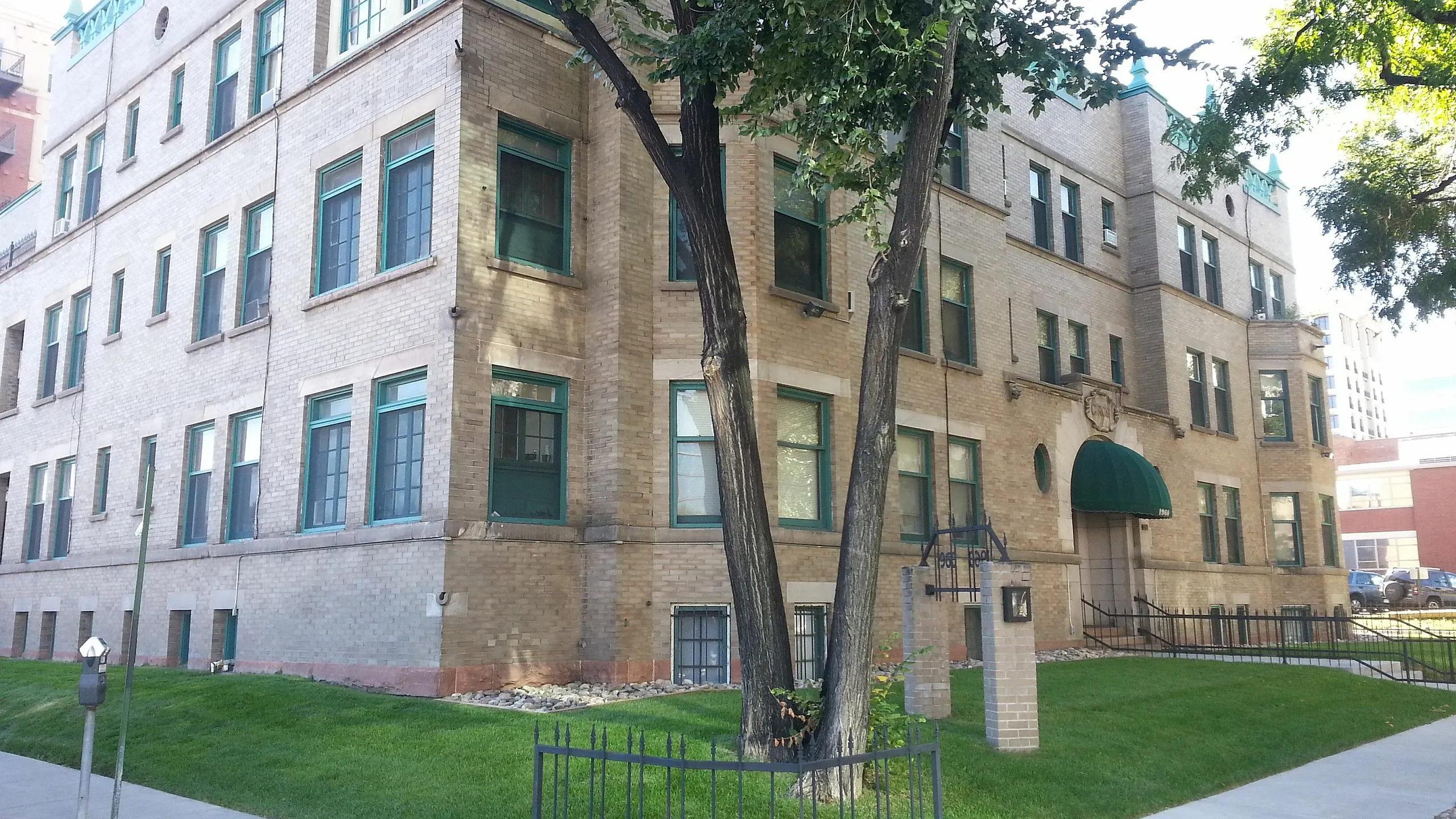 Beautiful historic apartment building with lush greenery and unique architectural details.