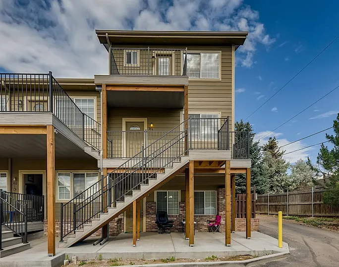 Contemporary three-story apartment building with spacious balconies and elegant staircases.