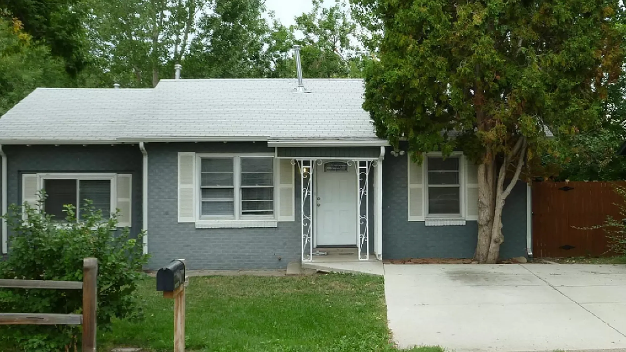 Cozy single-story house with a beautiful front yard and mature trees, perfect for family living.