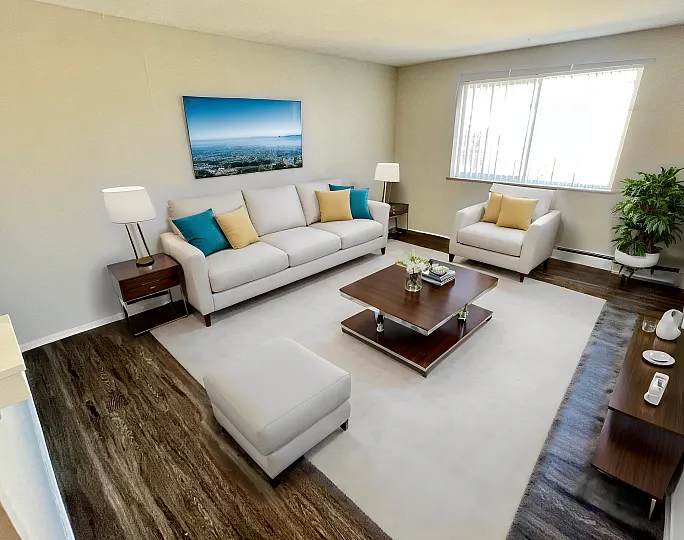 Bright, inviting living room with a large window, comfortable seating, and stylish decor.