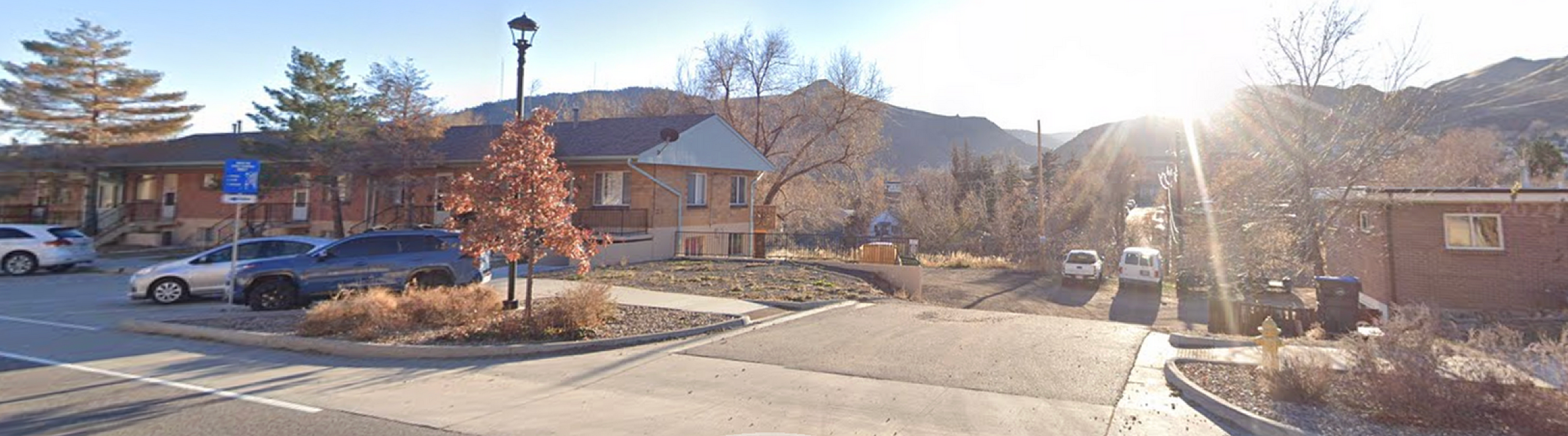 Inviting suburban neighborhood with brick houses and scenic mountain backdrop.