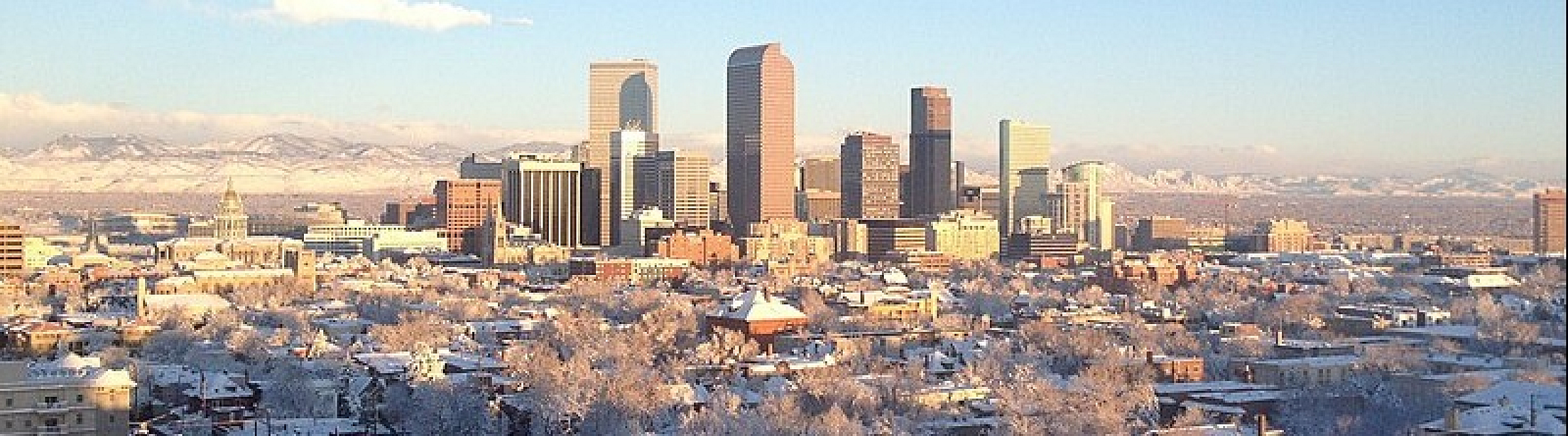 Breathtaking snowy cityscape view with a vibrant downtown skyline against a mountain backdrop, perfect for urban winter living.