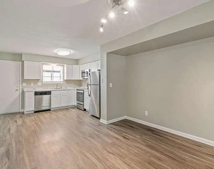 Bright and modern kitchen space featuring stainless steel appliances, elegant cabinetry, and sleek hardwood flooring, perfect for culinary creativity.