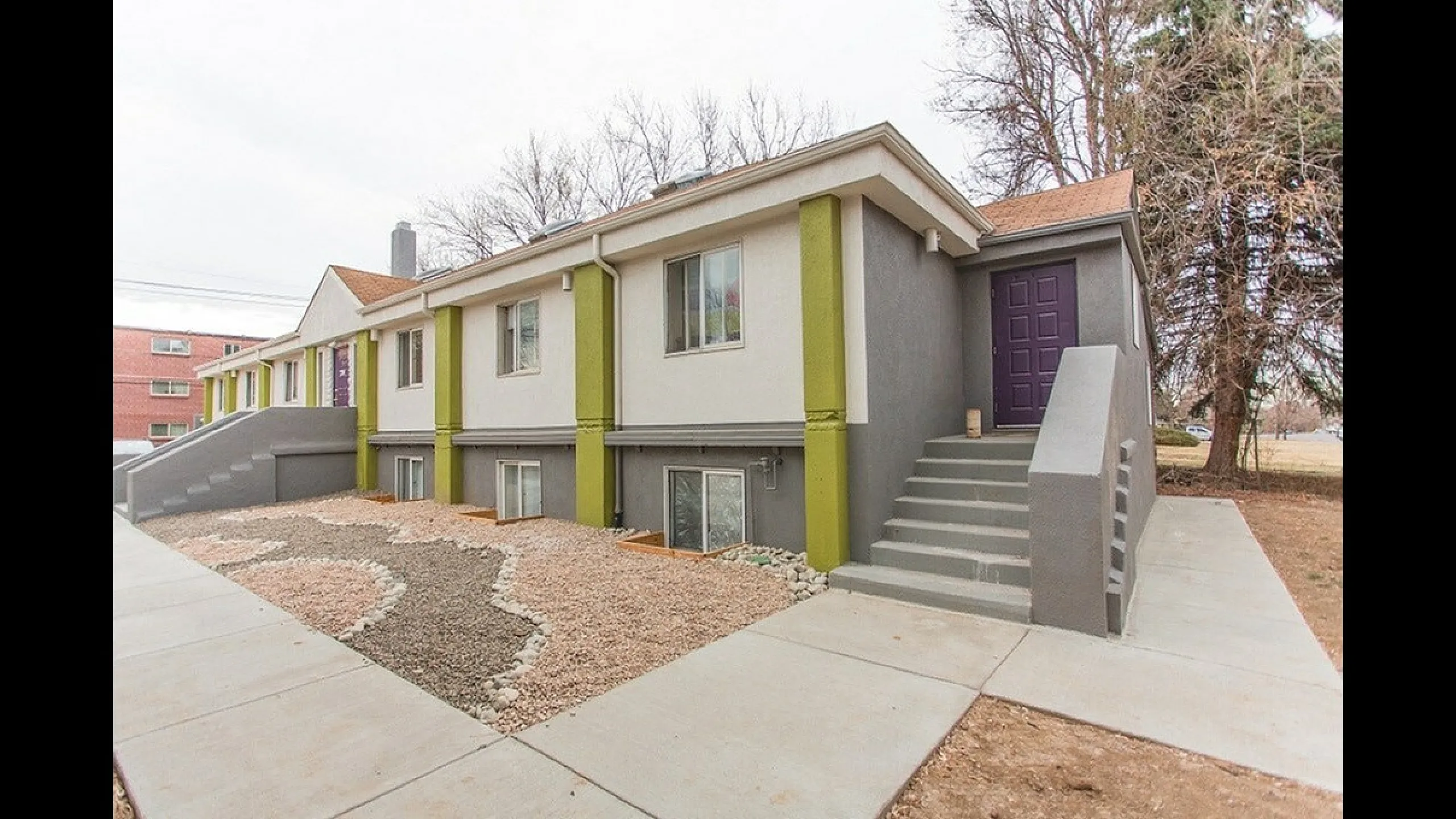 Charming modern gray and green accents, featuring landscaped front yard and inviting entrance steps.