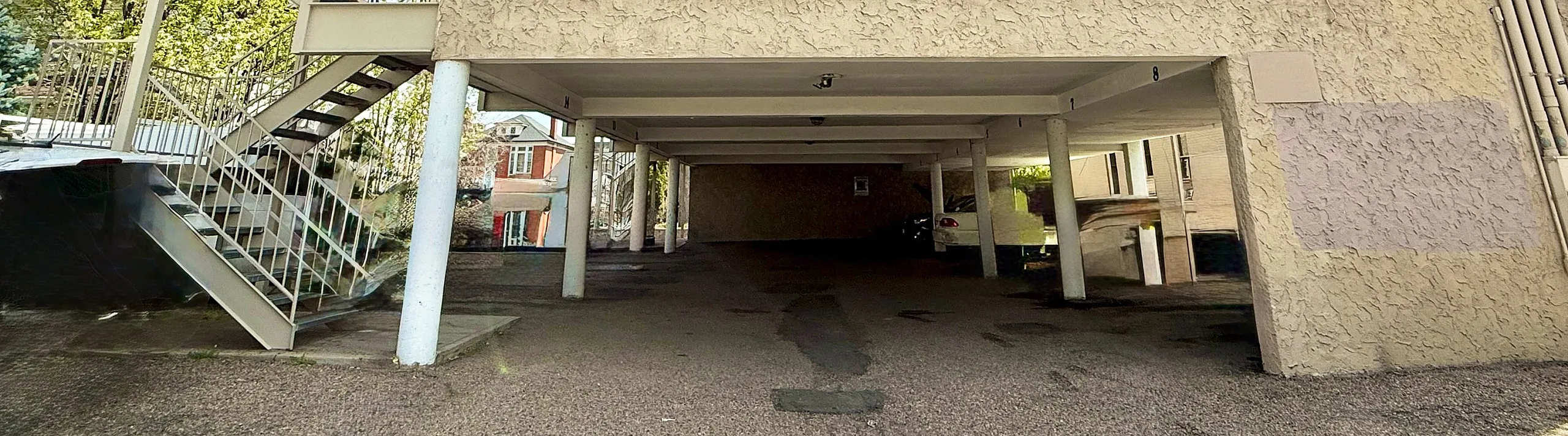 Bright apartment entrance with convenient parking and modern exterior staircase, perfect for easy access and urban living.