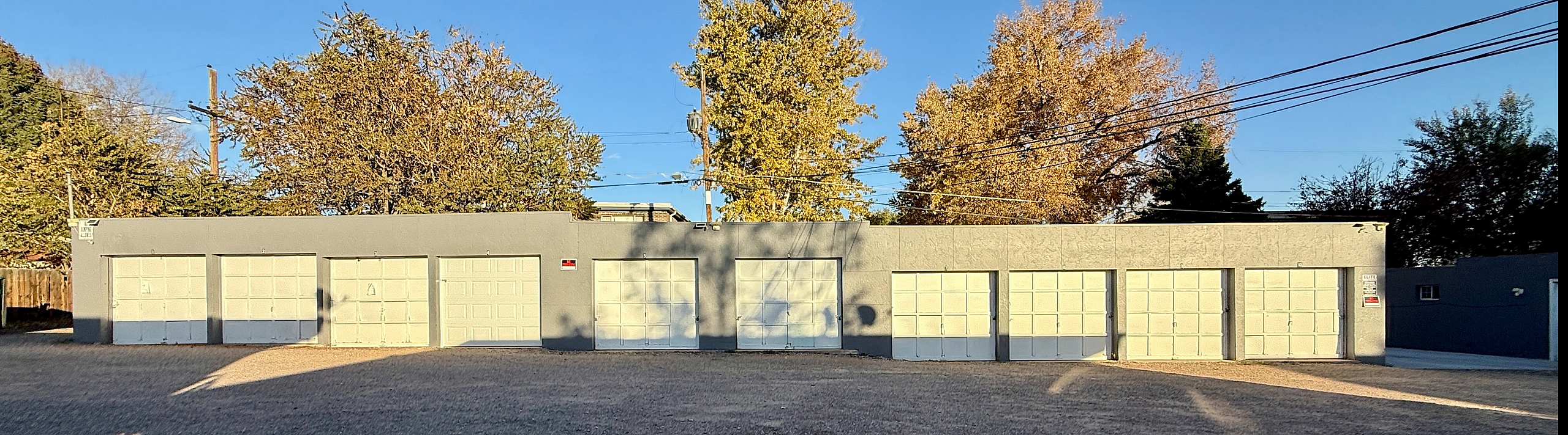 Chic apartment building with sleek garage doors and sunlit surroundings.