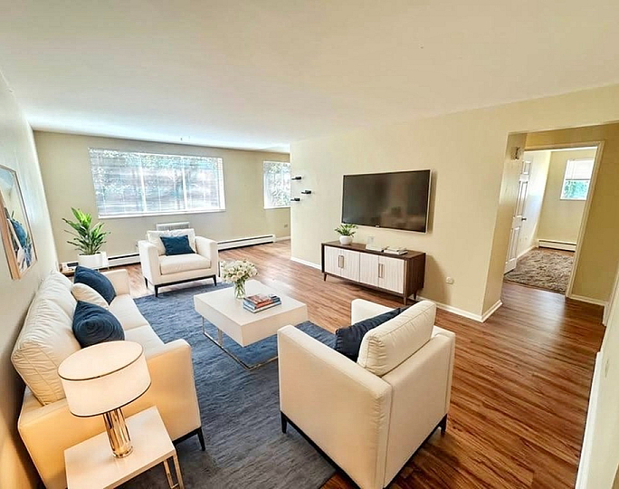 Inviting living room with modern decor, plush seating, and abundant natural light from large windows, creating a cozy and stylish atmosphere.