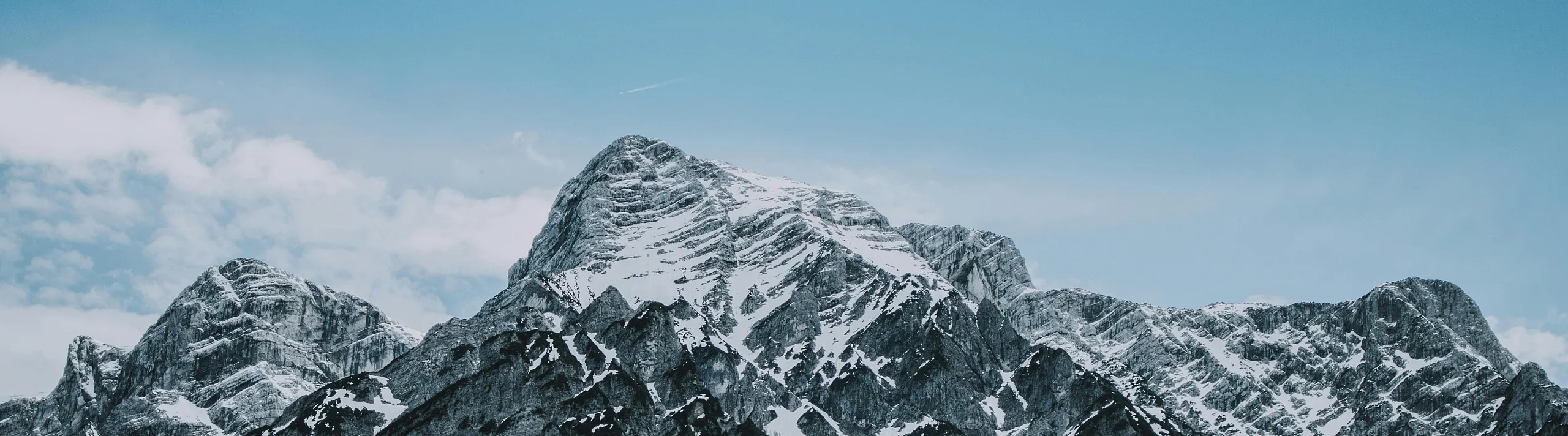 Majestic snow-capped mountain peaks under a vibrant blue sky, perfect for nature lovers and adventure seekers.