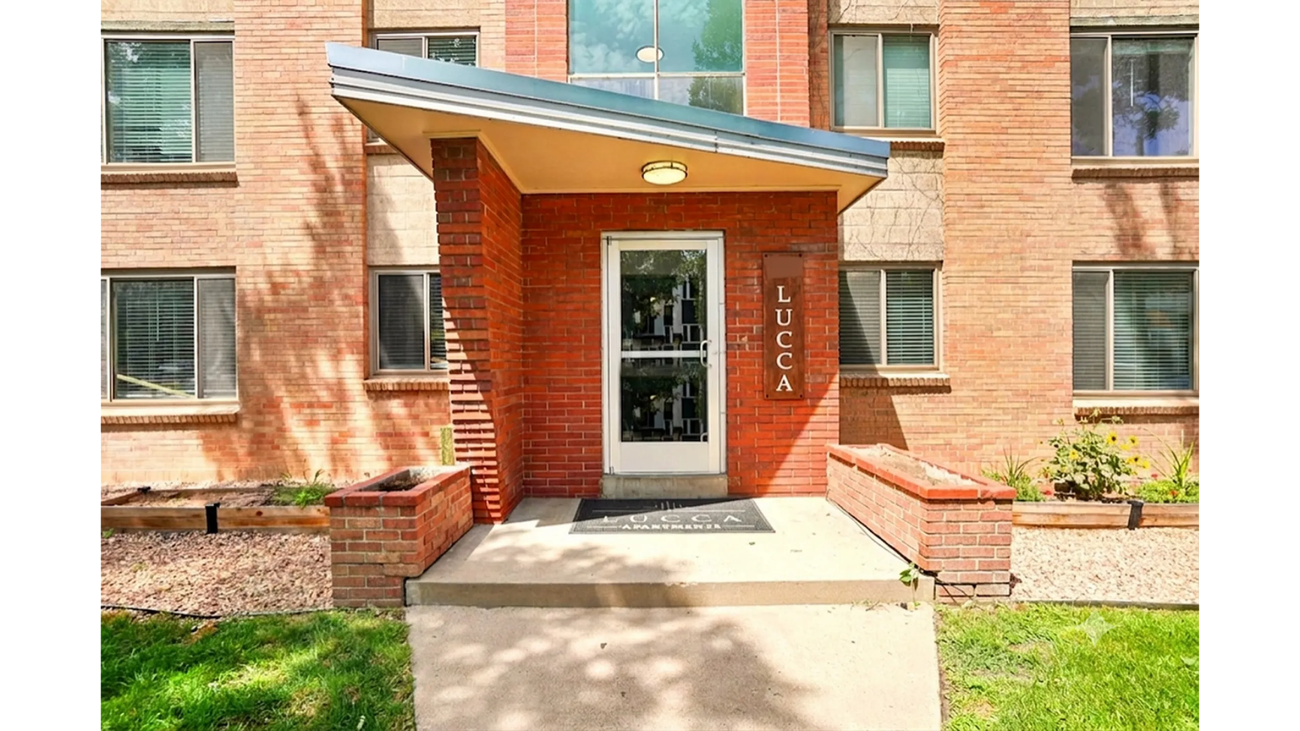 Welcoming entrance to Lucca Apartments adorned with elegant brickwork and modern design.