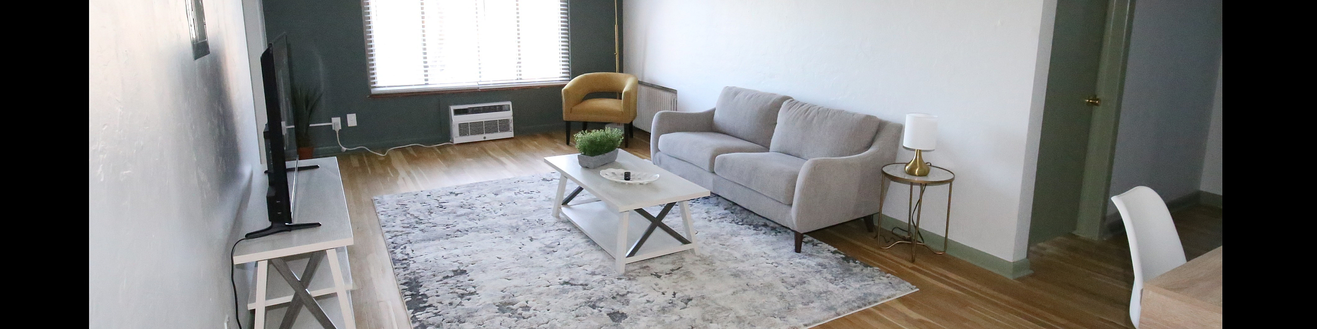 Bright and modern living room with a cozy gray sofa, stylish coffee table, and a large window inviting natural light.