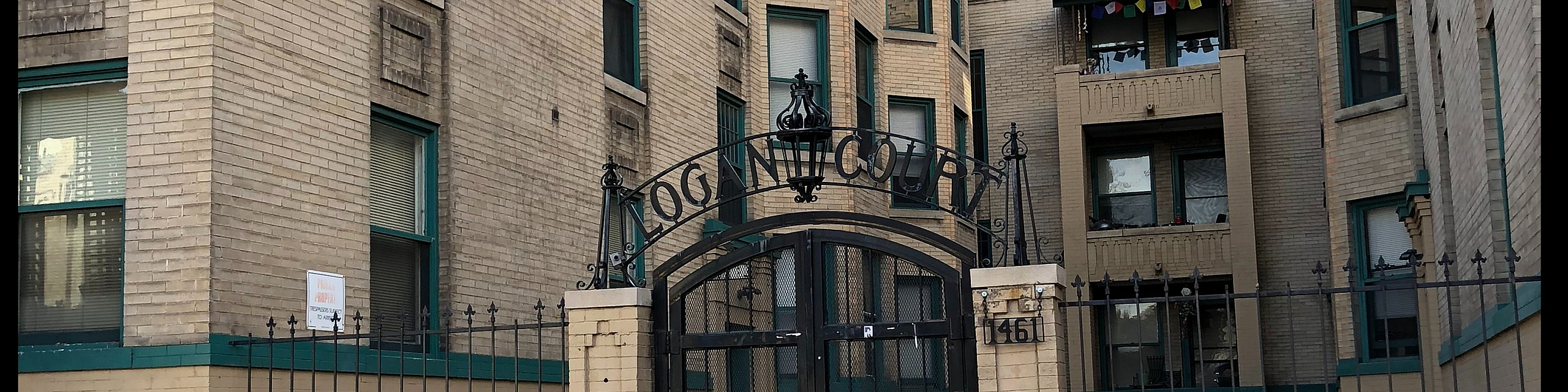 Charming brick apartment complex with elegant architectural details and welcoming gated entrance.