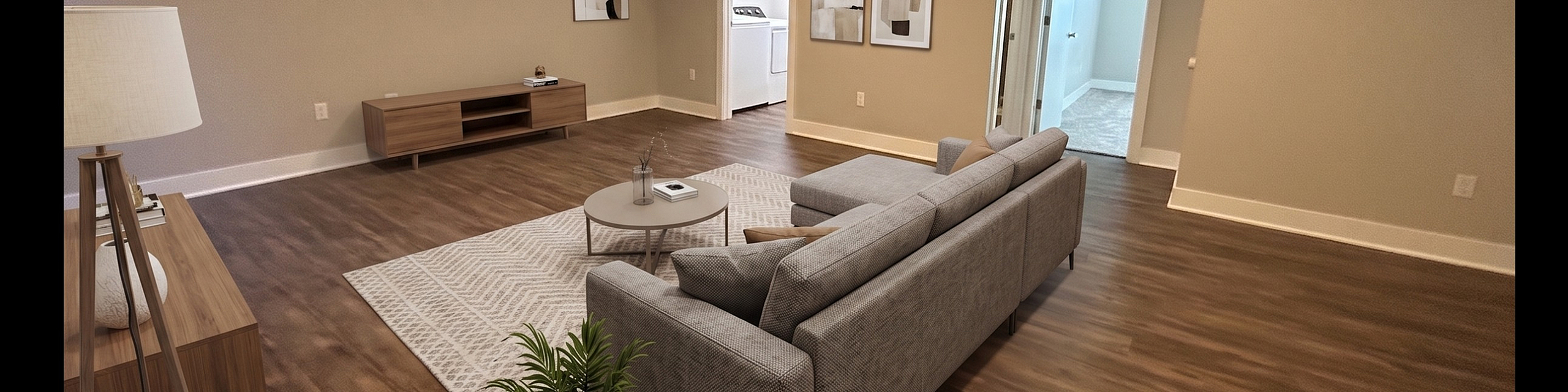 Inviting modern living room with elegant wood flooring, cozy gray sectional, and chic decor, perfect for relaxation and entertaining.