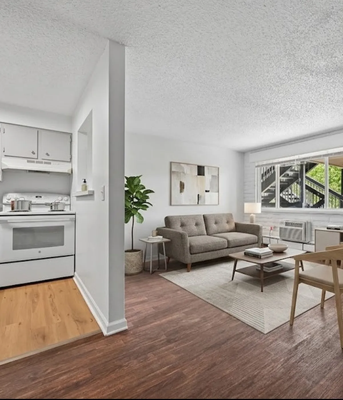 Modern open-concept living room and kitchen with chic furniture, wood flooring, and ample natural light.