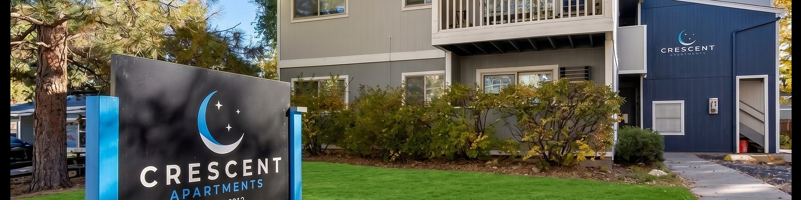 Charming Crescent Apartments with modern architecture, nestled among lush greenery and towering trees, featuring a welcoming front view and stylish balcony.