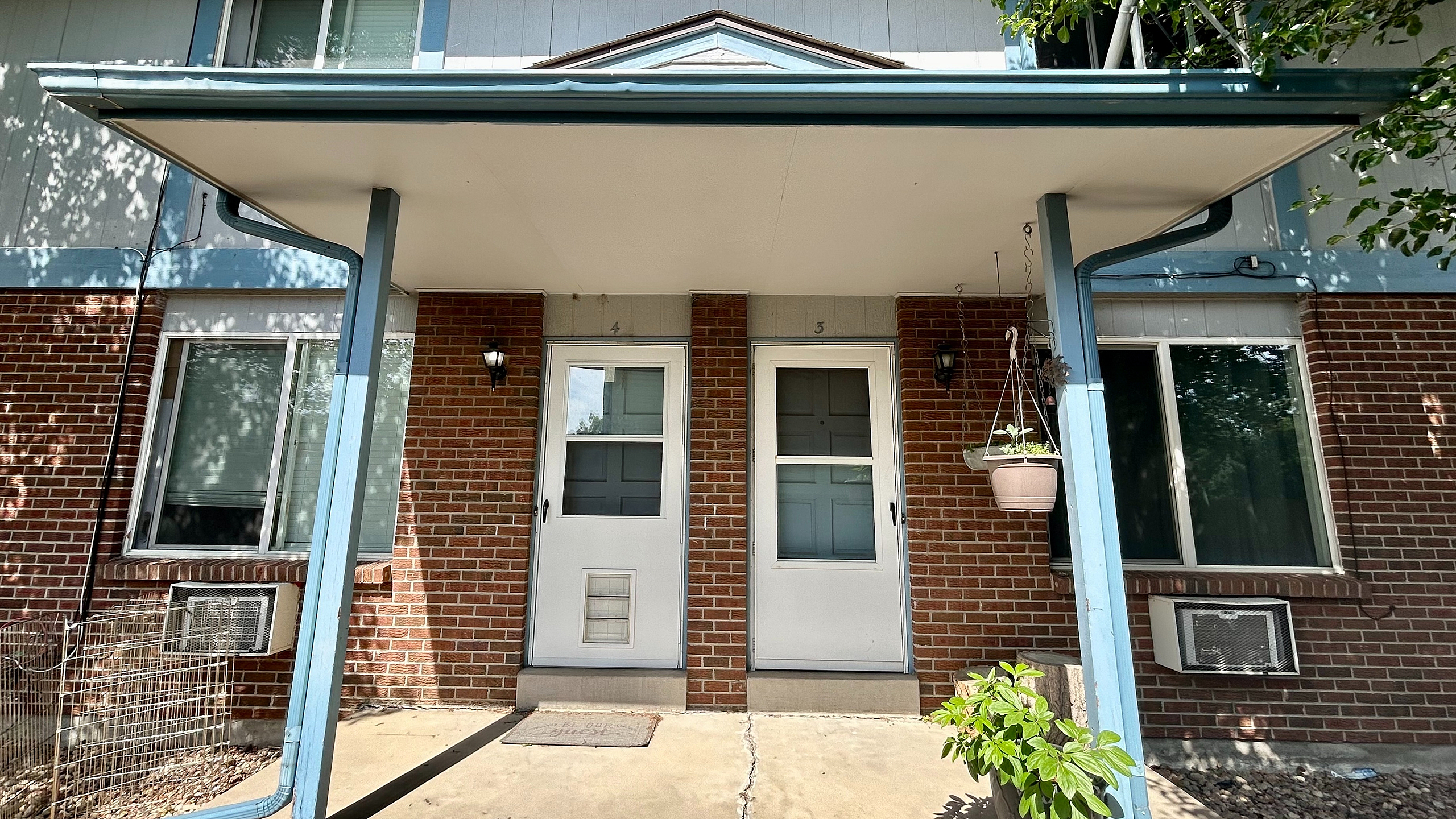 Charming brick townhouse entrance with inviting covered porch and modern accents, perfect for cozy living.