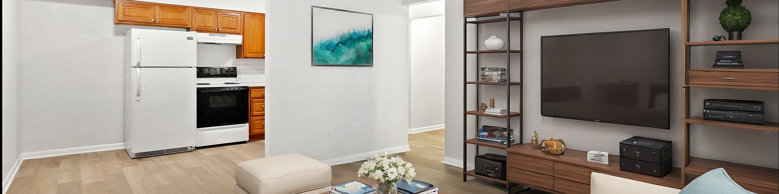 Inviting open-concept living room with elegant shelving, cozy seating, and a seamless transition to the kitchen featuring modern appliances and warm wooden cabinetry.