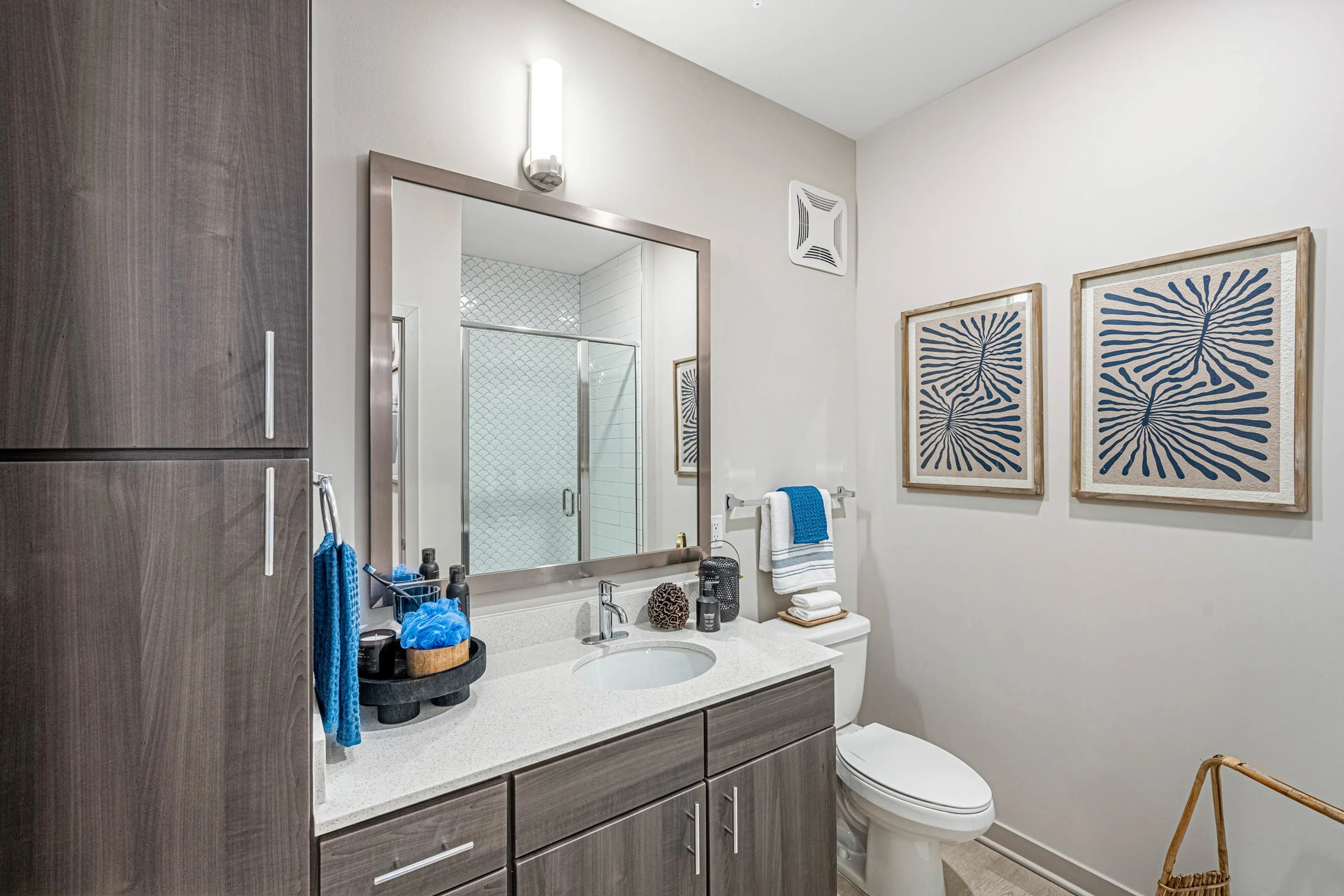 Furnished bathroom with large vanity and linen shelving