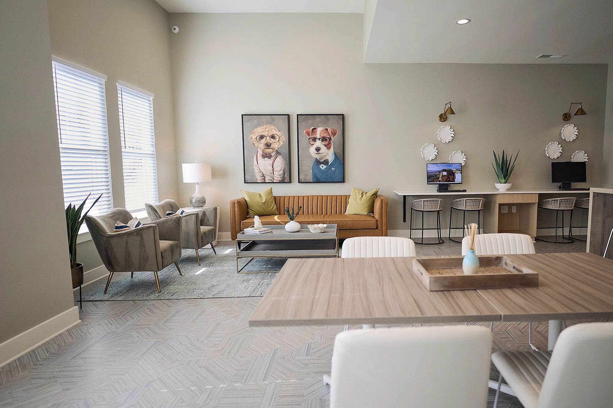 Stylish living room with modern furniture, featuring artwork of dogs in suits and a cozy workspace.