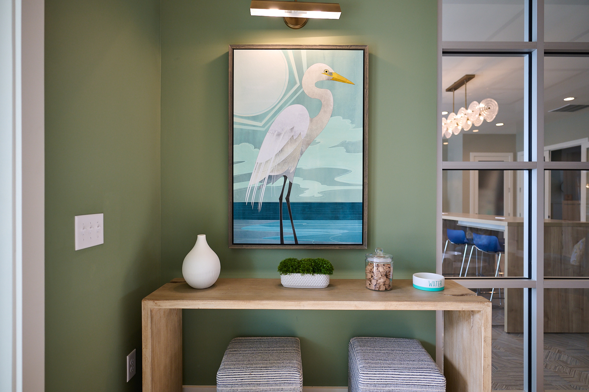 Charming corner nook with a stylish bird painting, modern wooden table, and cozy seating.