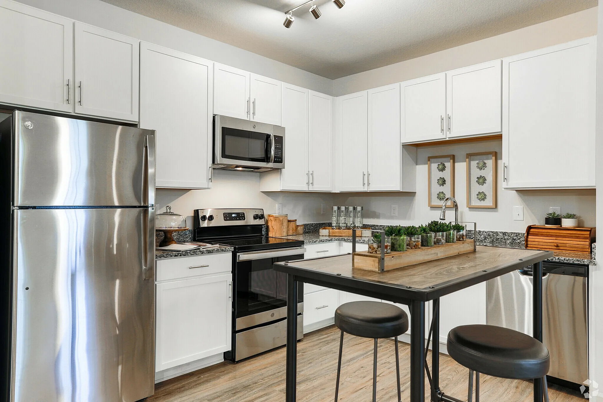 Elegant modern kitchen featuring stainless steel appliances, white cabinets, and a chic breakfast bar.
