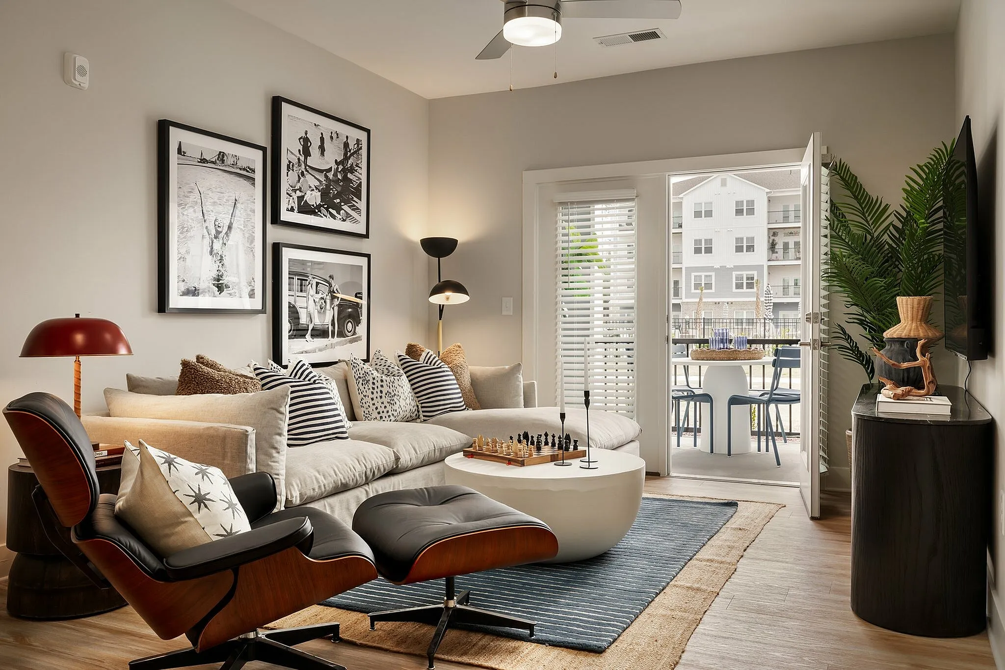 Stylish living room with contemporary decor, large sofa, art pieces, and a view of the balcony.