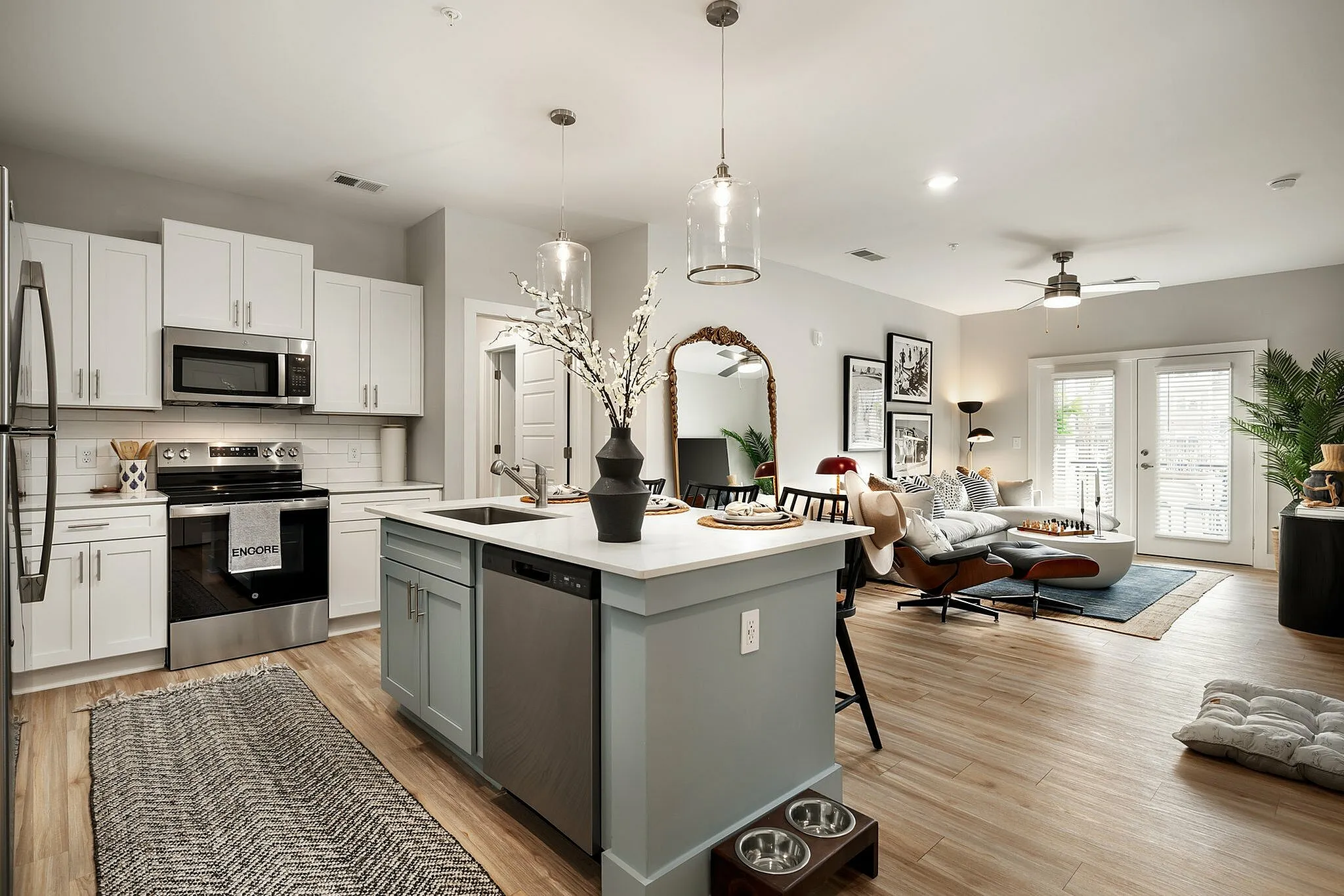 Modern open-concept kitchen with a stylish island and a cozy living area with natural light and elegant decor.