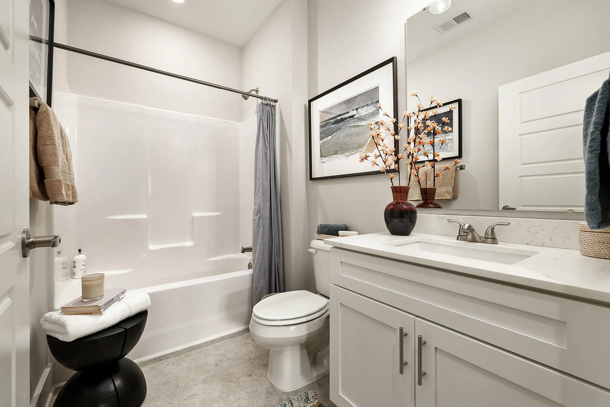Sophisticated bathroom featuring a modern bathtub, sleek white vanity, and elegant decor accents.