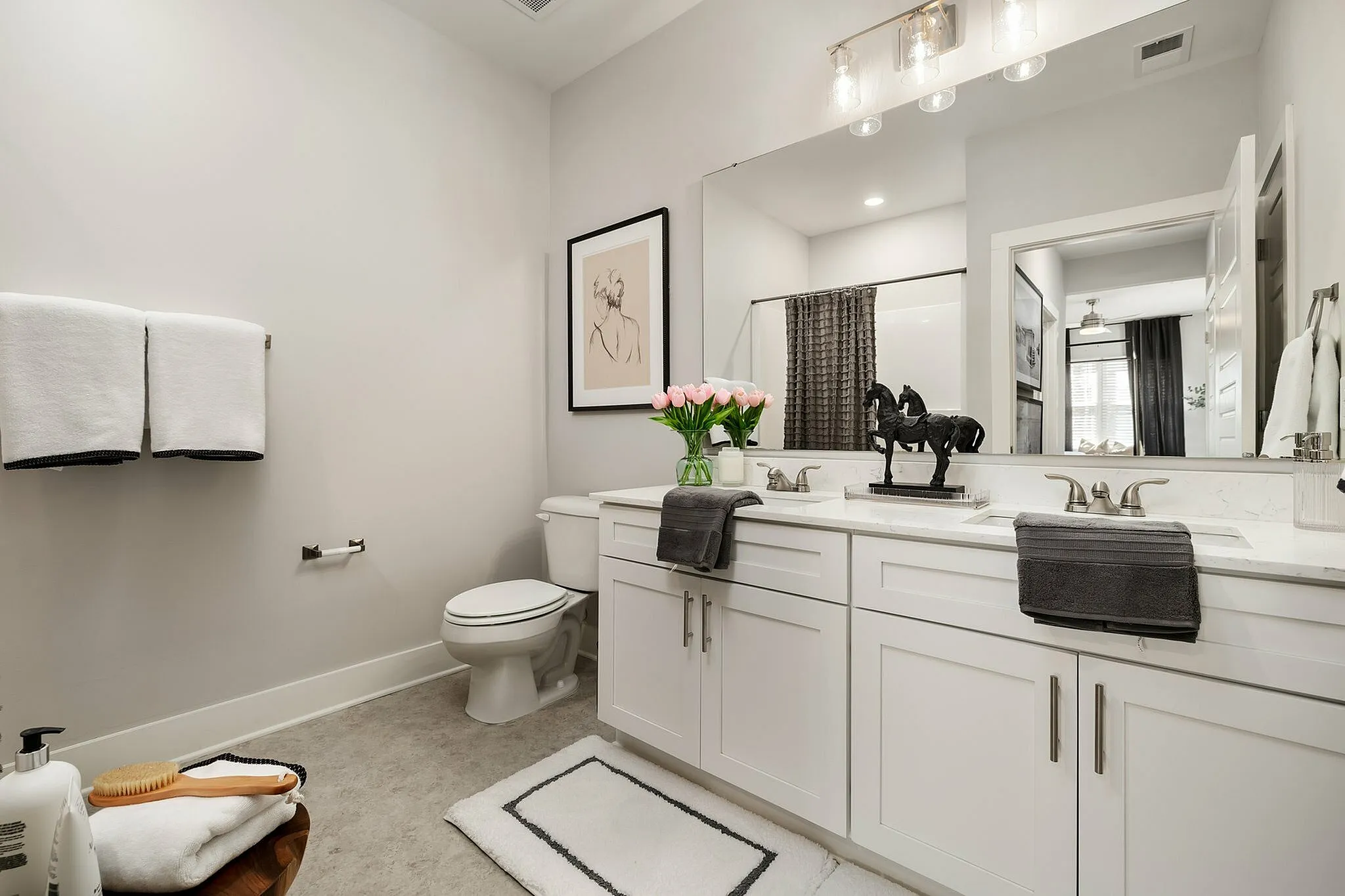 Luxurious bathroom featuring dual sinks, modern decor, and elegant lighting.