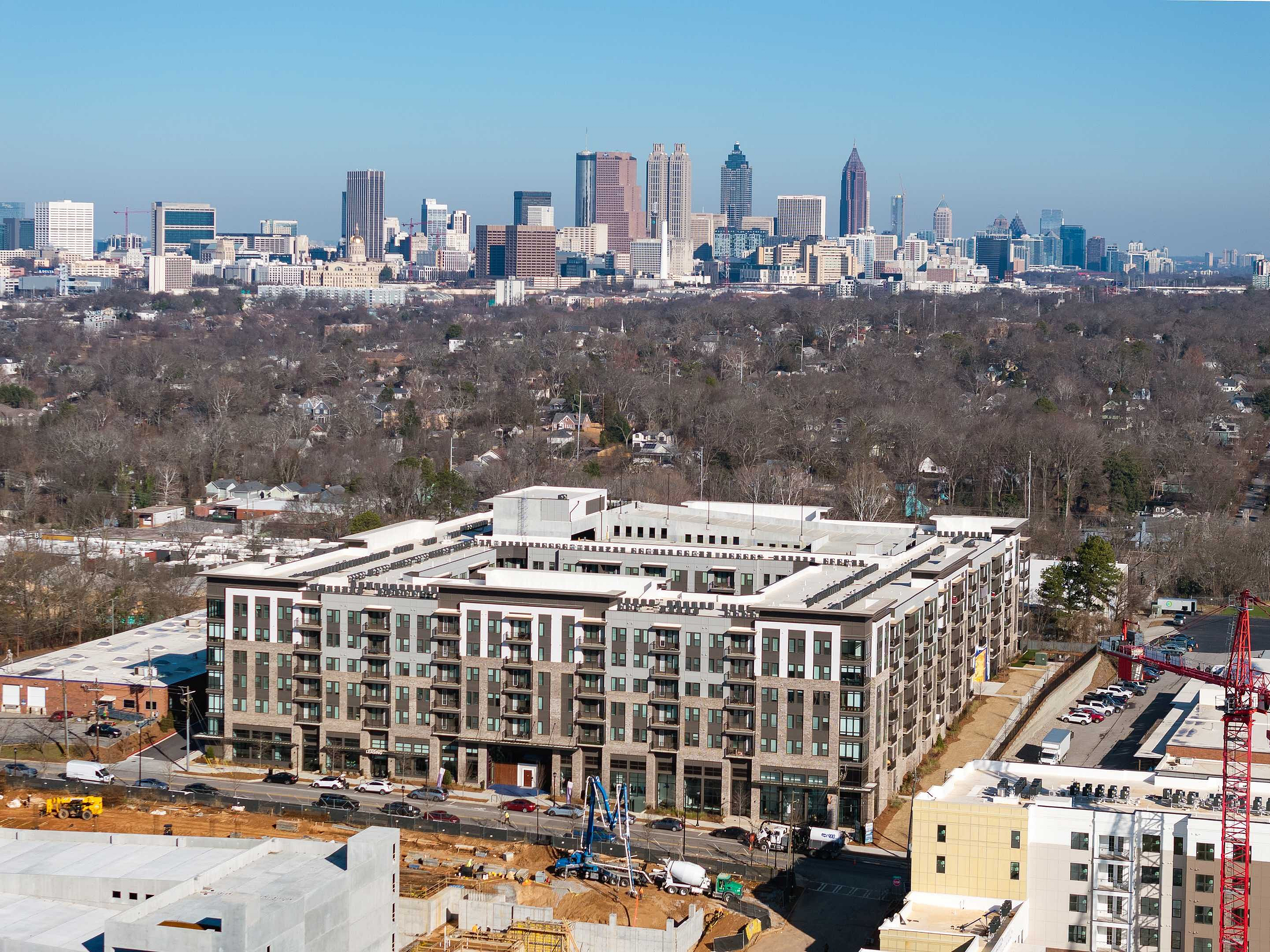 Modern apartment complex with a stunning city skyline backdrop, showcasing urban living with luxury and convenience.