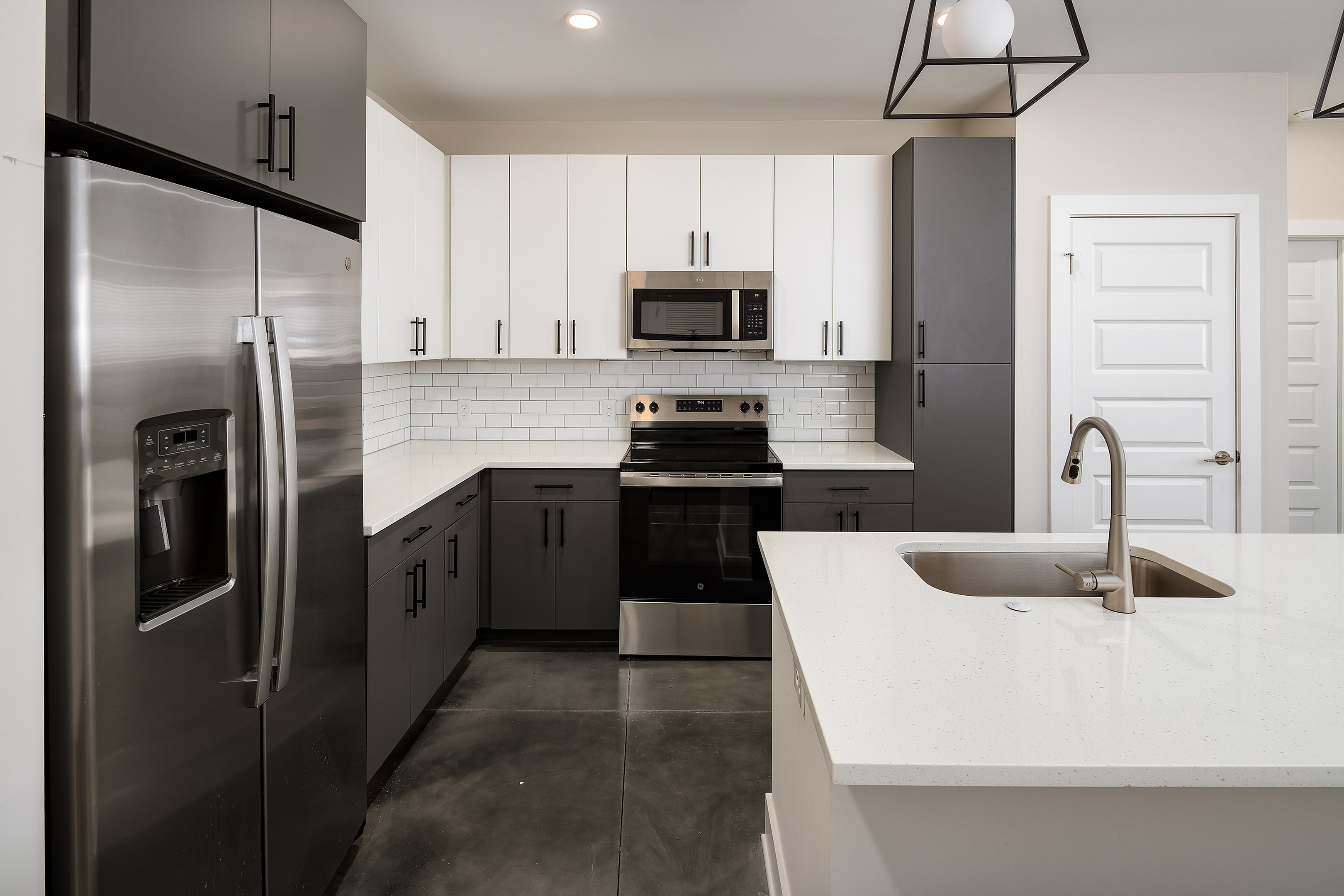 Modern kitchen with sleek stainless steel appliances, elegant cabinetry, quartz countertops, and stylish subway tile backsplash.