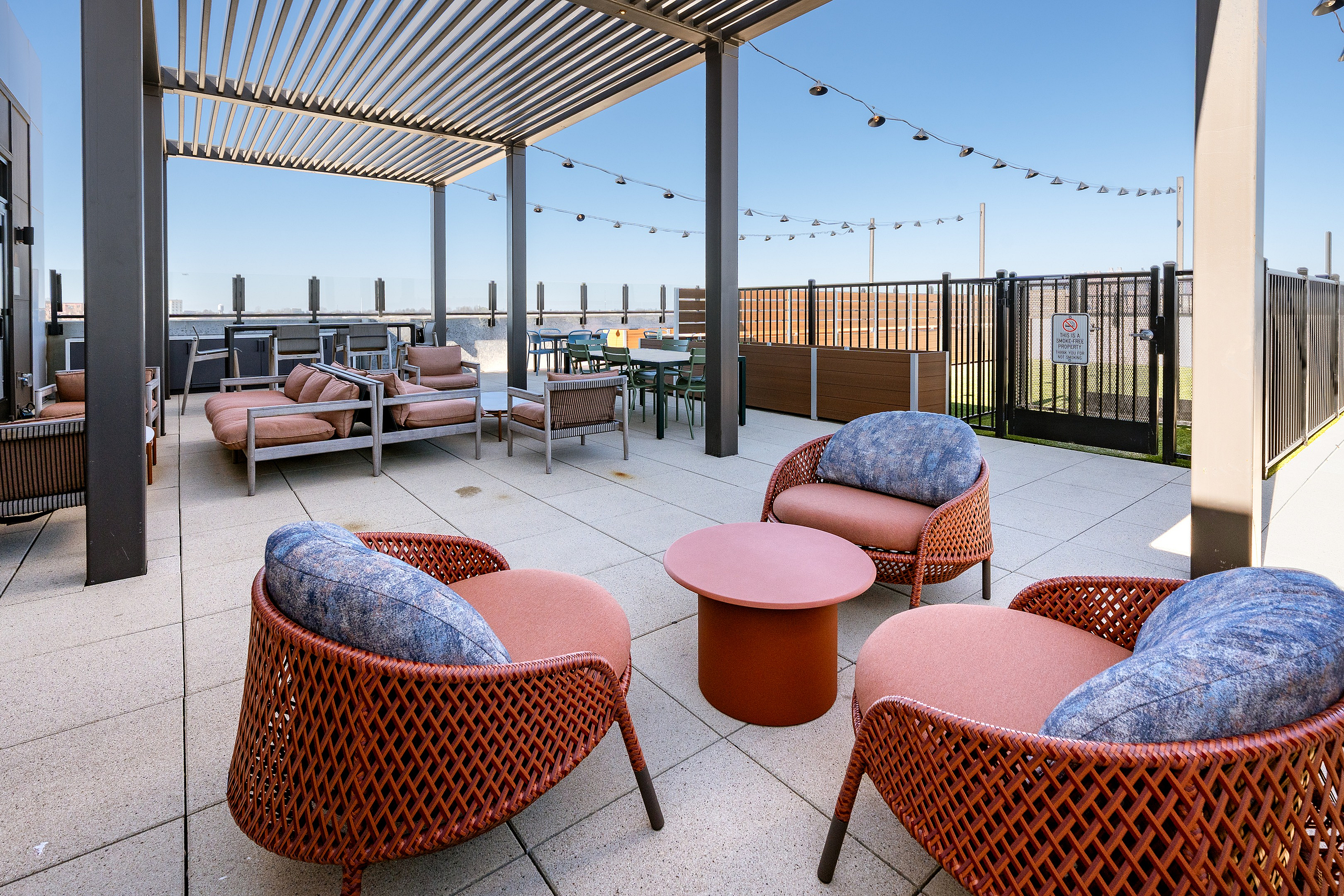 Modern rooftop patio with stylish seating, outdoor dining area, and open sky views, perfect for relaxation and entertaining.