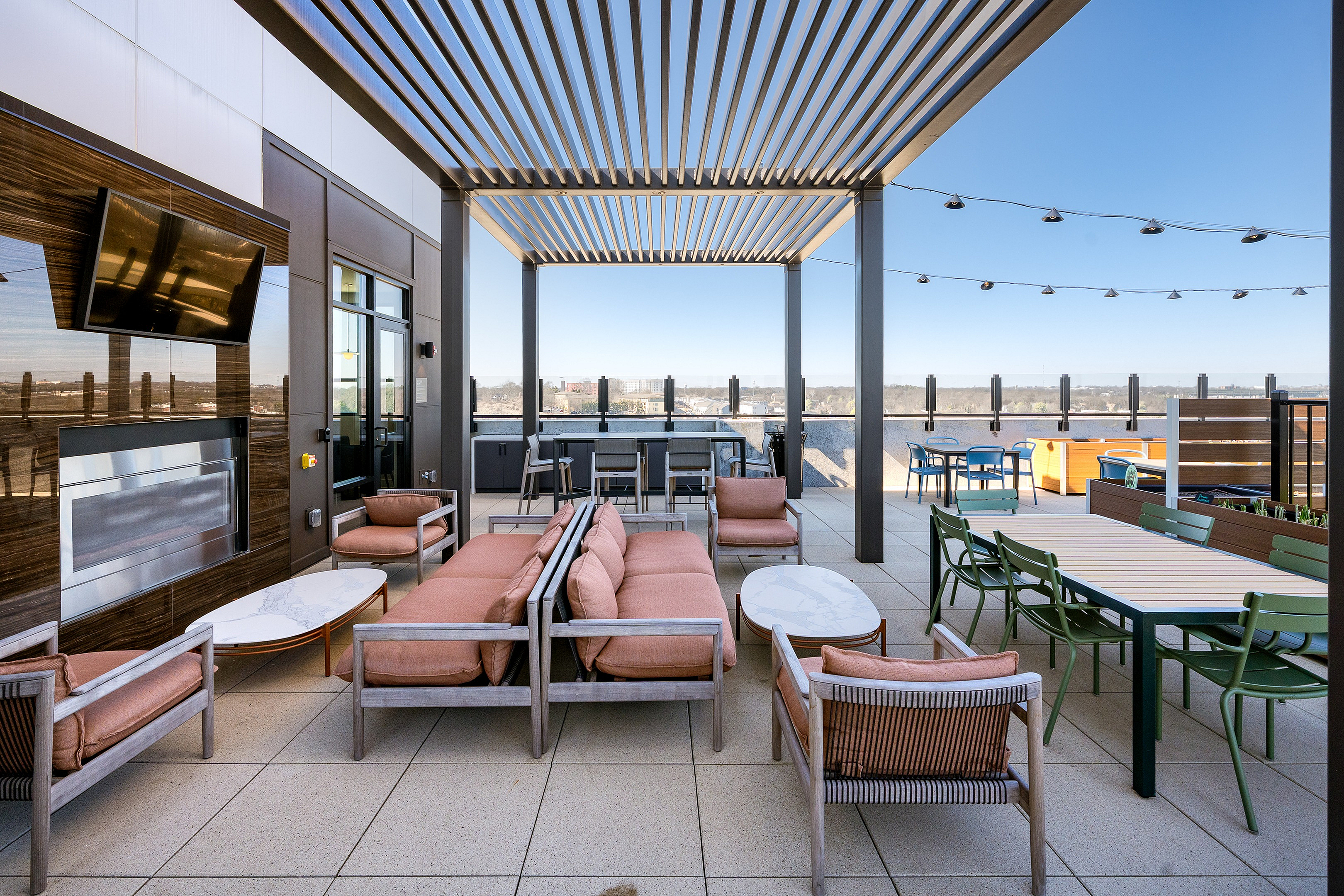Luxurious rooftop patio with plush seating, stylish pergola, and panoramic city views; perfect for entertaining and relaxation.