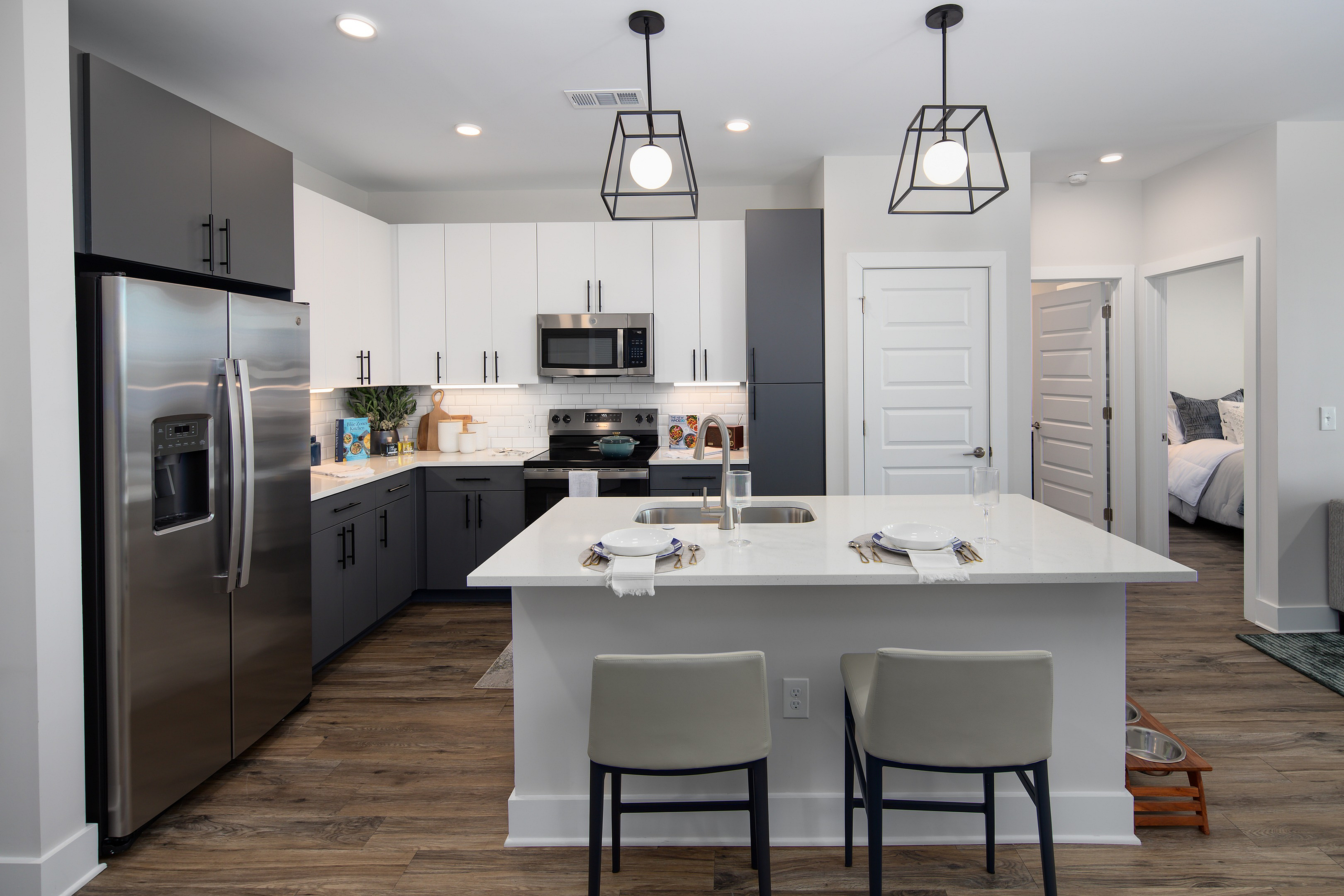 Chic modern kitchen with sleek stainless steel appliances, elegant cabinetry, and a stylish island with seating for two. Bright, inviting, and perfect for entertaining.