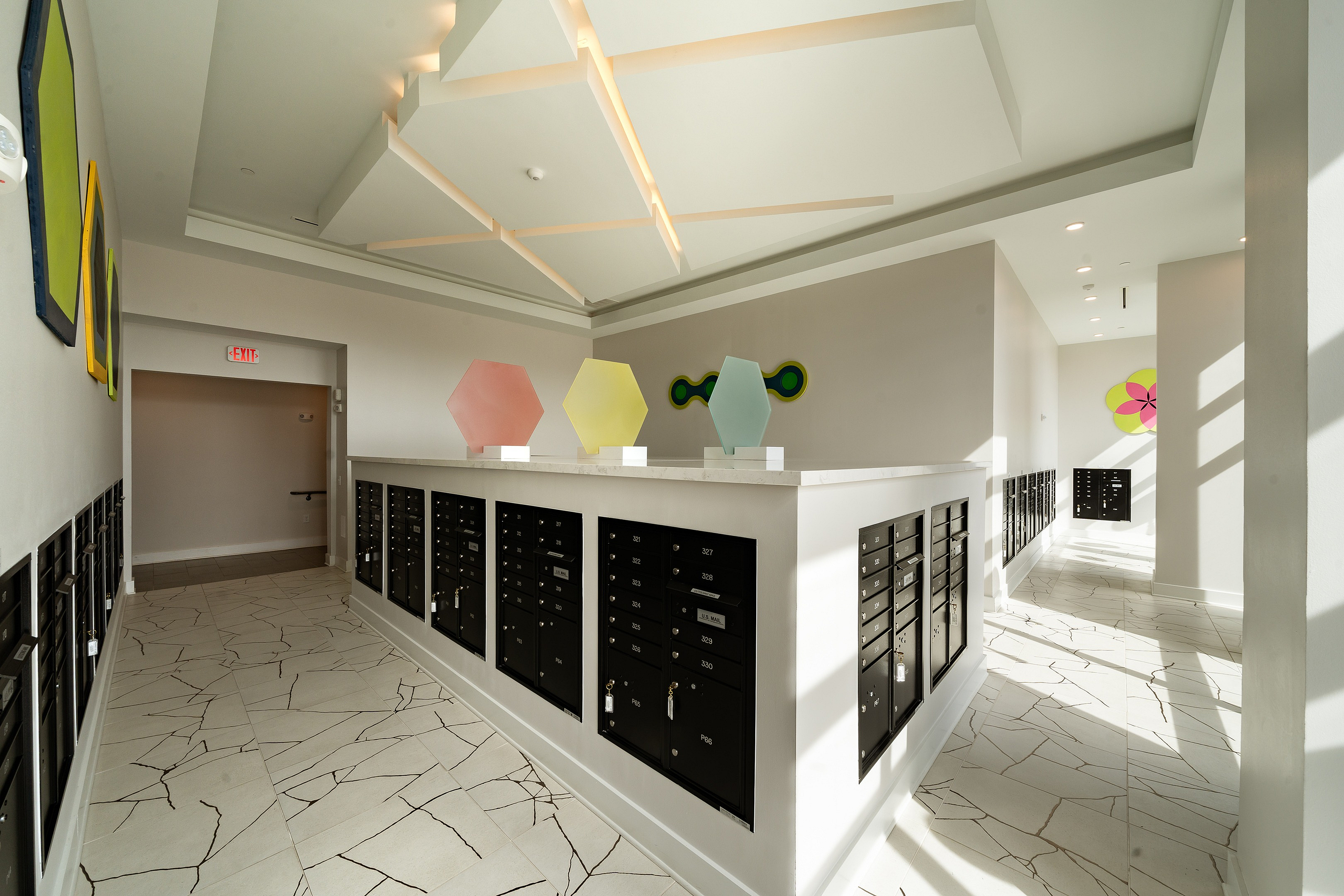 Modern mailbox area with sleek design, geometric art pieces, and unique tiled floor, offering a stylish postal solution.