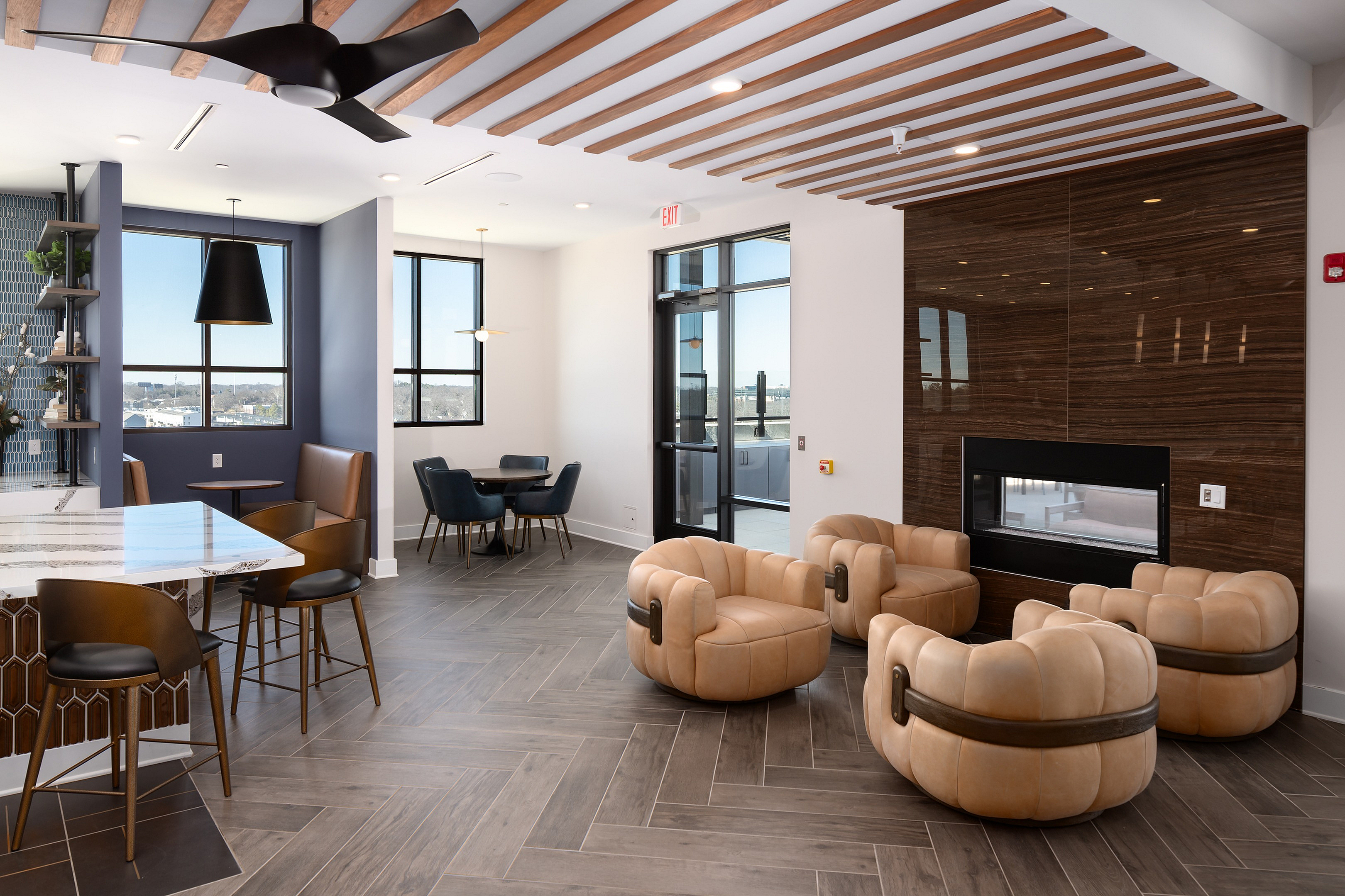Modern open-concept lounge featuring comfortable seating, sleek wooden accents, and expansive windows offering stunning city views.