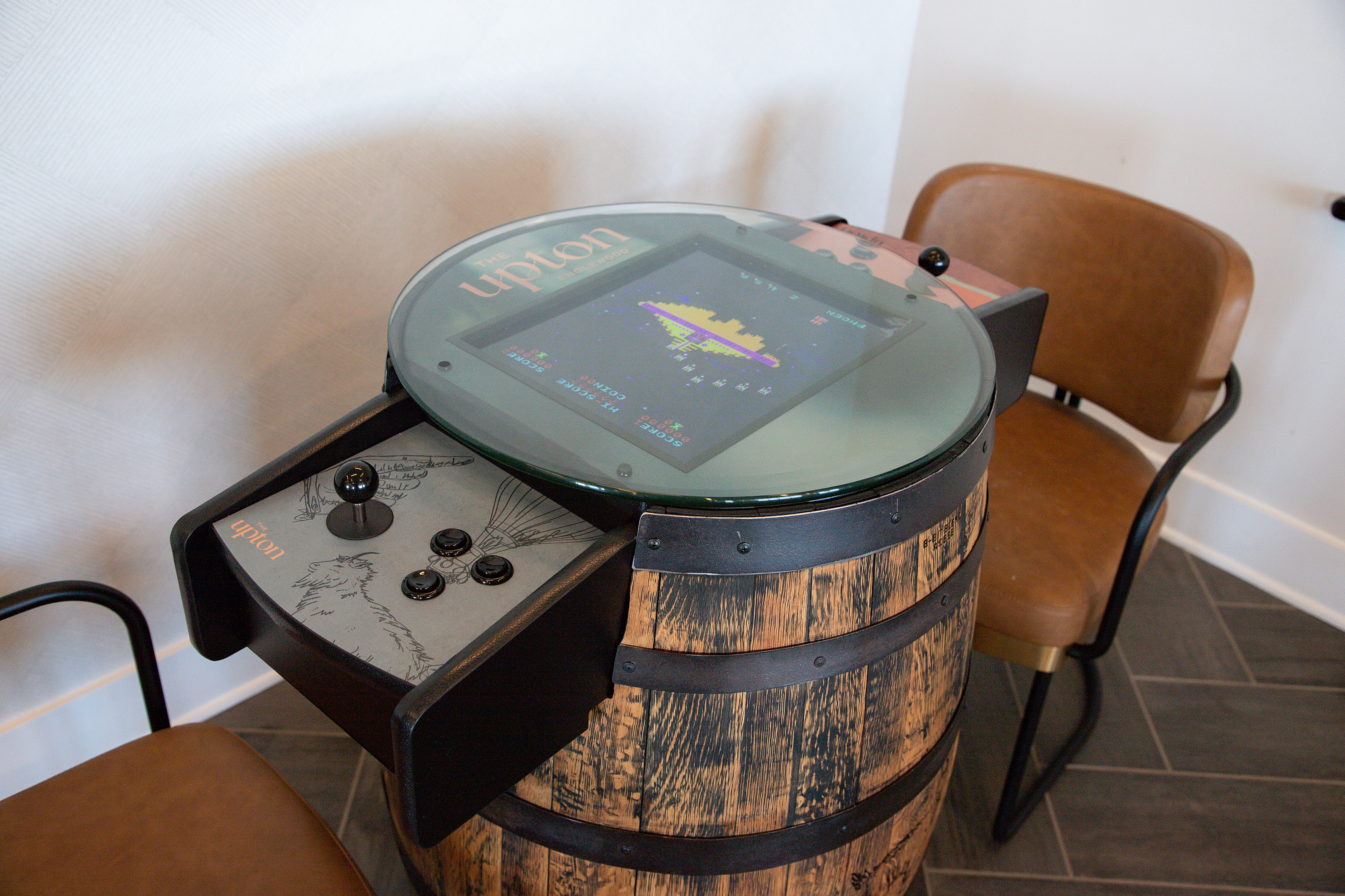 Unique vintage arcade setup featuring a barrel-style cabinet with classic gaming controls and a vibrant screen, perfect for entertainment in any living space.