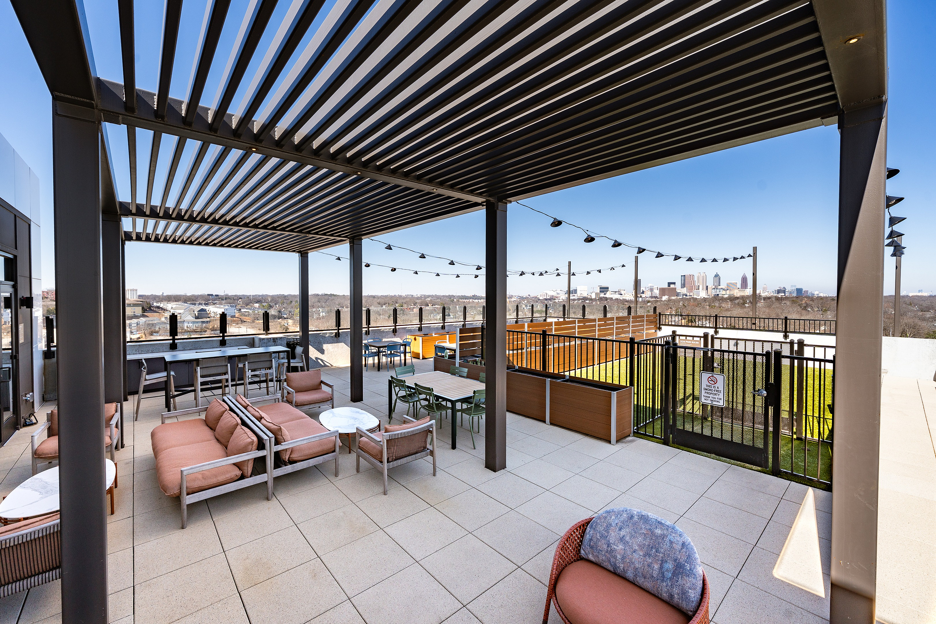 Modern rooftop terrace with stylish pergola and cozy seating, offering stunning cityscape views and a relaxed outdoor ambience.